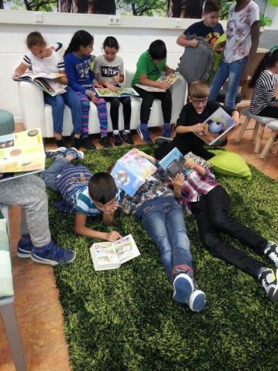 Leerlingen van Brede School de Zonnewende in Nijmegen genieten van het lezen van boeken op een groene vloer. Leerlingen van Brede School de Zonnewende in Nijmegen genieten van het lezen van boeken op een groene vloer.
