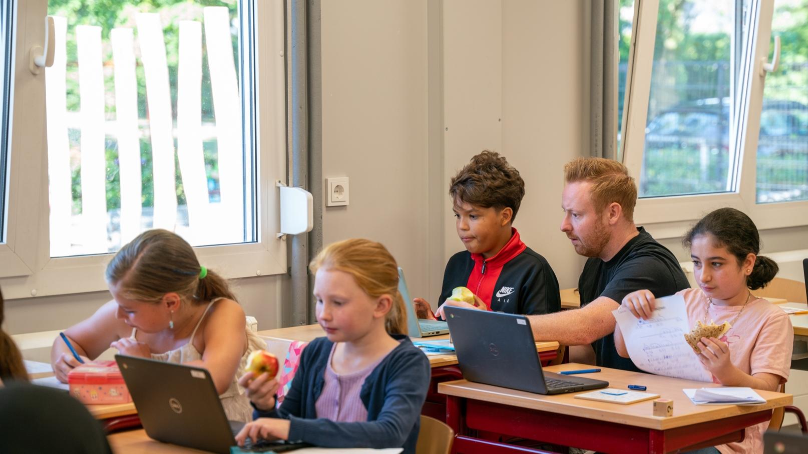Leerlingen van BS Hertogin Johanna A in Oss zijn actief aan het werk in de klas met laptops en fruit. Leerlingen van BS Hertogin Johanna A in Oss zijn actief aan het werk in de klas met laptops en fruit.
