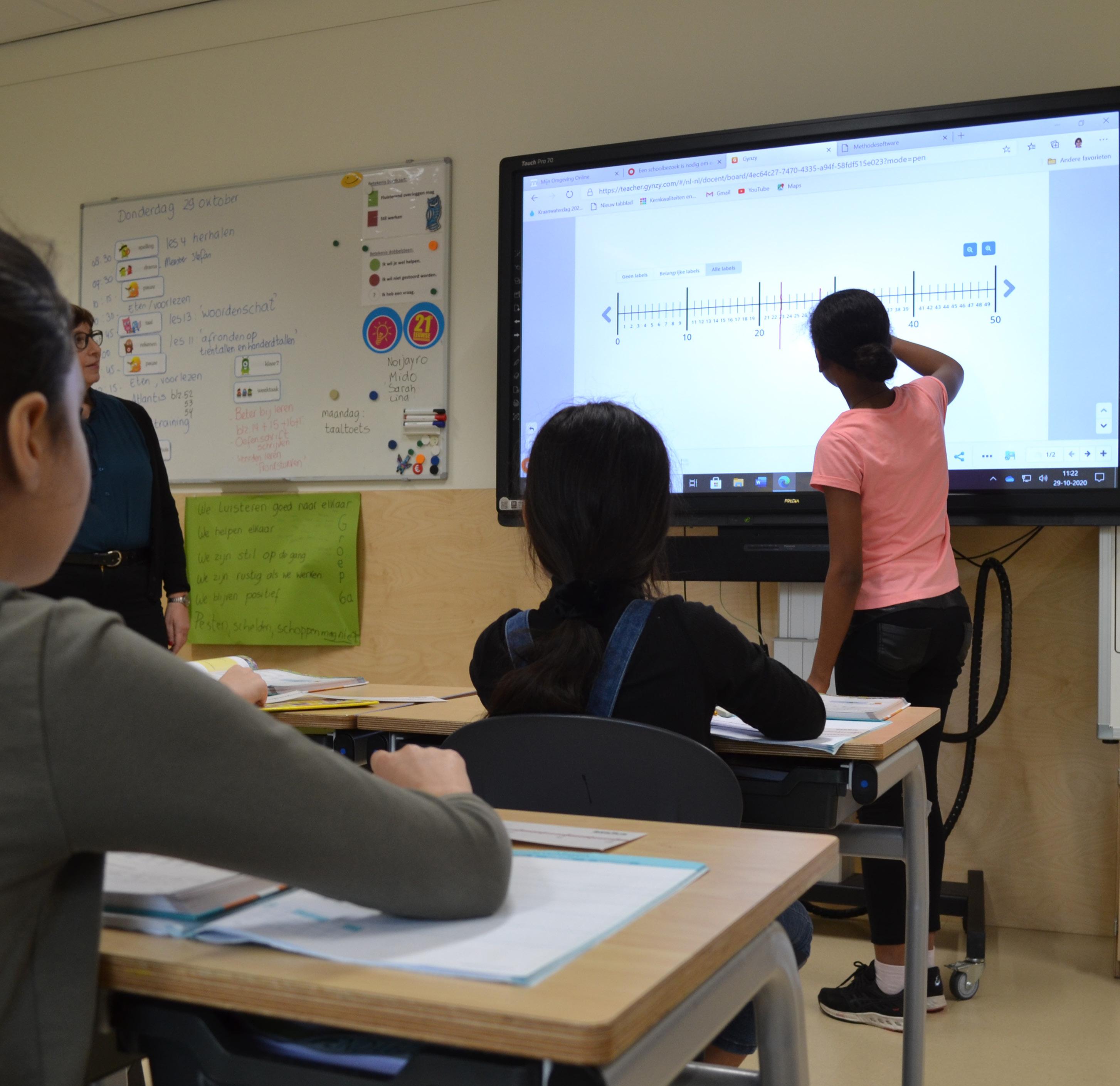 Leerlingen van Burgemeester De Vlugtschool in Amsterdam volgen een interactieve les met een digitaal bord. Leerlingen van Burgemeester De Vlugtschool in Amsterdam volgen een interactieve les met een digitaal bord.