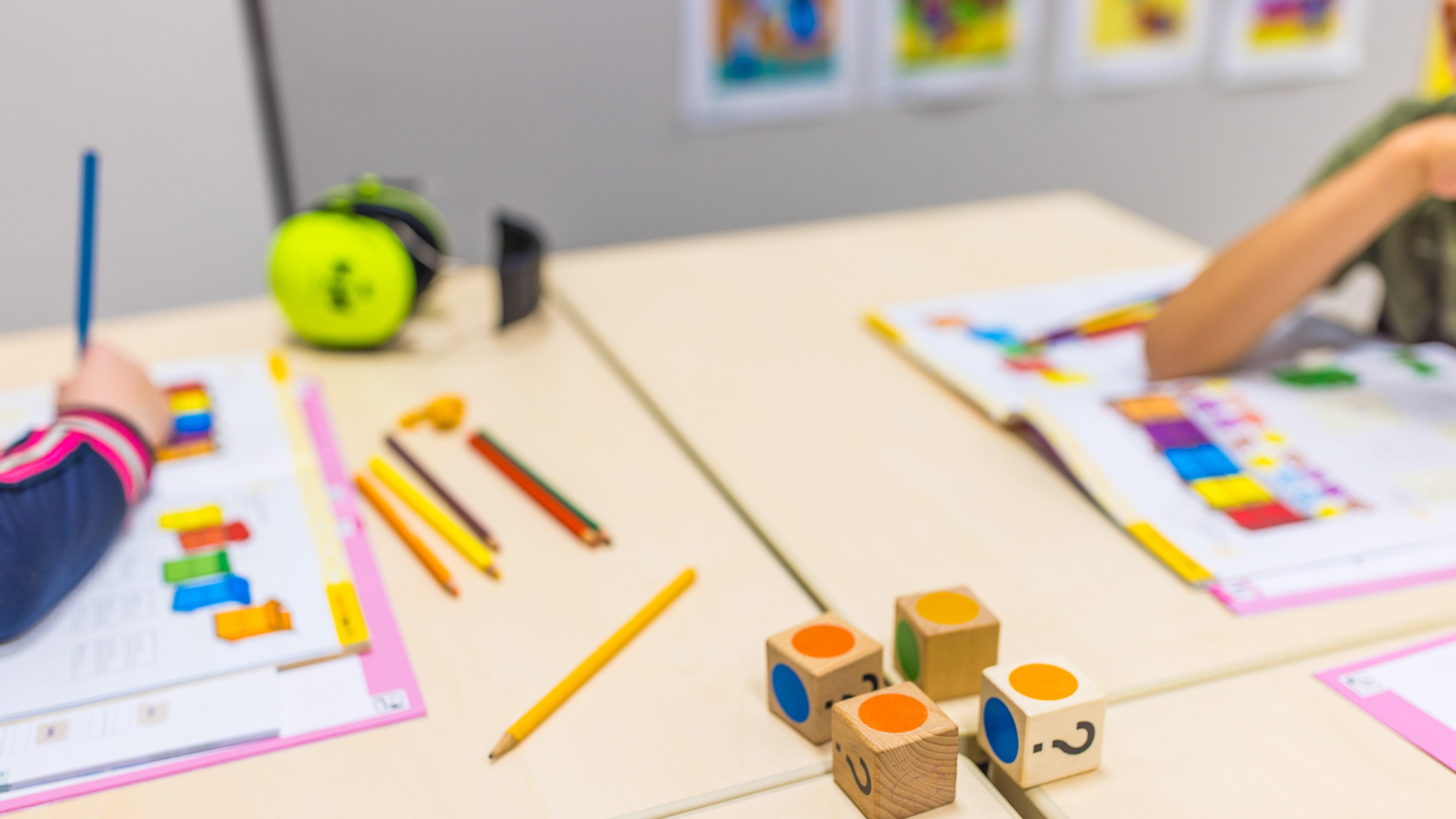 Leerlingen van CBS De Parel in Roden zijn actief aan het werk met kleurige blokken en schoolmateriaal aan hun tafel. Leerlingen van CBS De Parel in Roden zijn actief aan het werk met kleurige blokken en schoolmateriaal aan hun tafel.