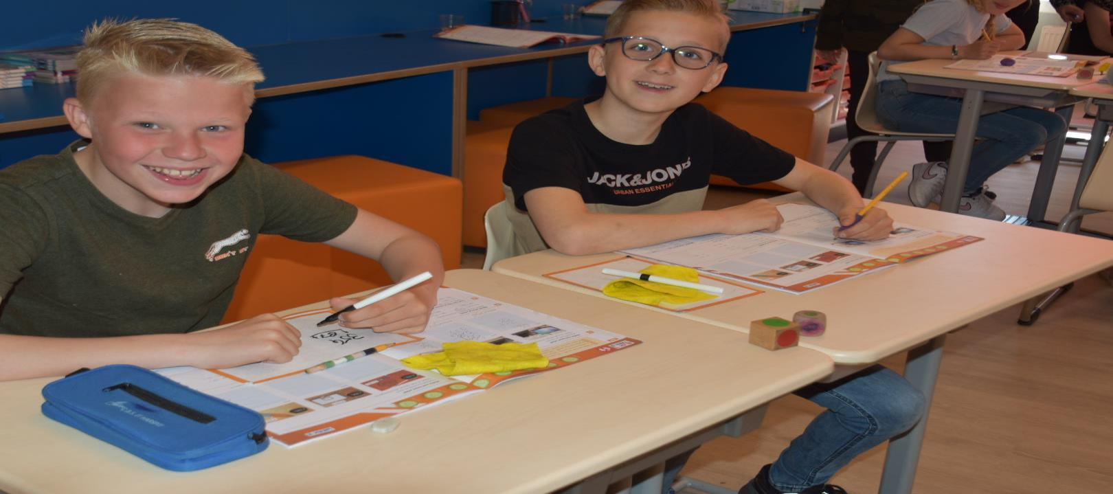 Leerlingen van CBS It Harspit in Ternaard zijn actief bezig met hun schoolwerk aan een kleurrijke tafel. Leerlingen van CBS It Harspit in Ternaard zijn actief bezig met hun schoolwerk aan een kleurrijke tafel.