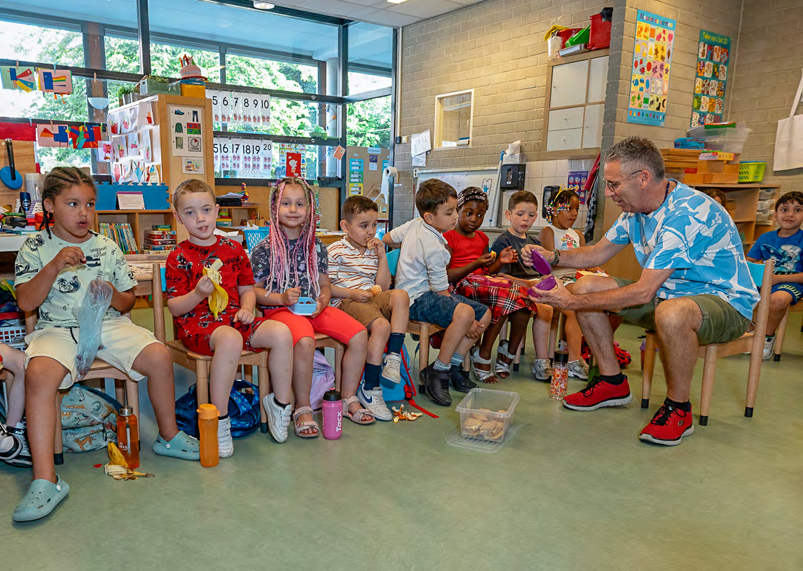 Leerlingen van CBS Mozaïek in Rotterdam zitten in de klas en luisteren aandachtig naar hun leraar.