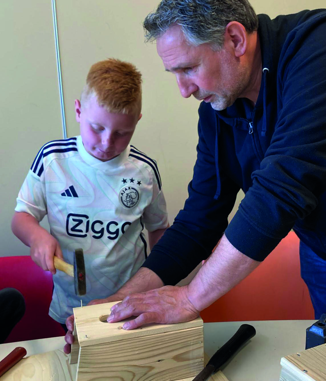 Leerlingen van Christelijke Basisschool De Bron in Wezep leren houtbewerking met begeleiding van een volwassene.