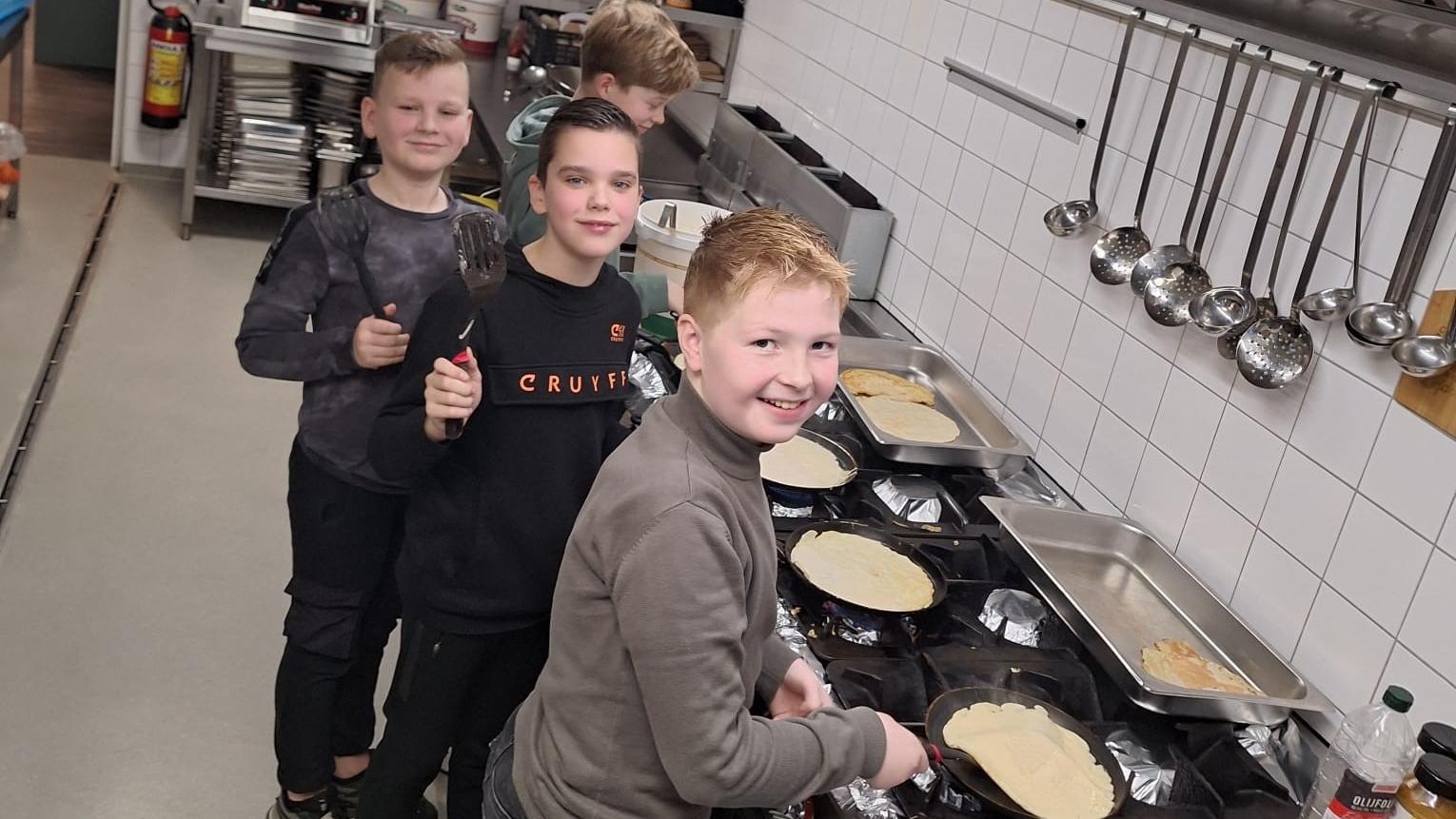 Leerlingen van Christelijke Basisschool De Veenbrug in Daarlerveen staan samen in de keuken en bereiden pannenkoeken. Leerlingen van Christelijke Basisschool De Veenbrug in Daarlerveen staan samen in de keuken en bereiden pannenkoeken.