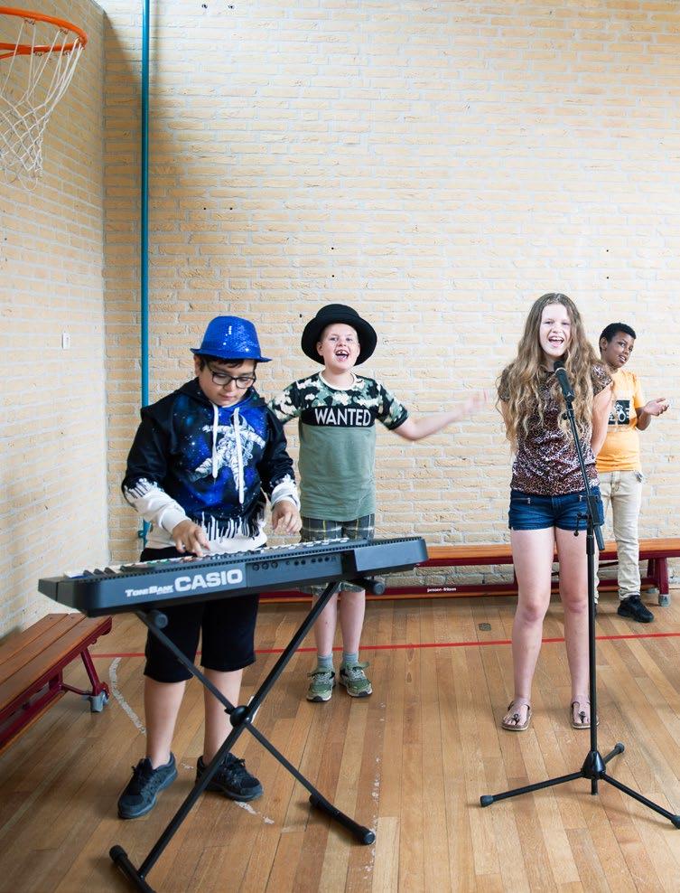Leerlingen van De Alk in Alkmaar voeren een muzieknummer op in de gymzaal. Leerlingen van De Alk in Alkmaar voeren een muzieknummer op in de gymzaal.