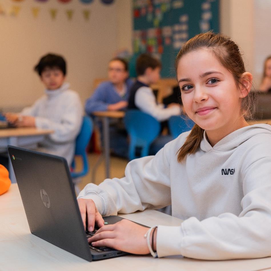 Leerlingen van de Bernardusschool in Den Haag zijn actief aan het werk op hun laptops in de klas. Leerlingen van de Bernardusschool in Den Haag zijn actief aan het werk op hun laptops in de klas.