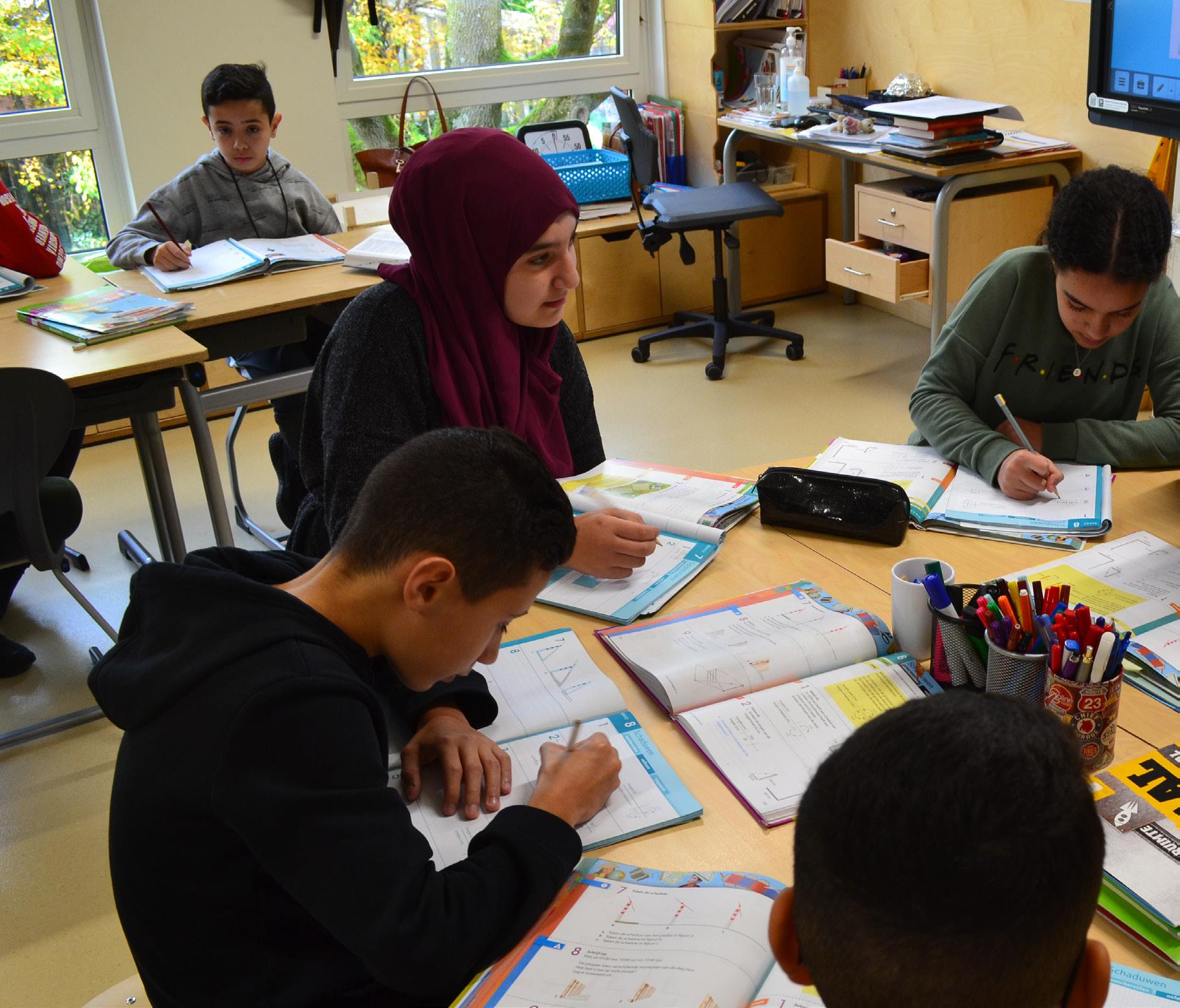 Leerlingen van de Burgemeester De Vlugtschool in Amsterdam werken samen aan hun schoolwerk in een klaslokaal. Leerlingen van de Burgemeester De Vlugtschool in Amsterdam werken samen aan hun schoolwerk in een klaslokaal.