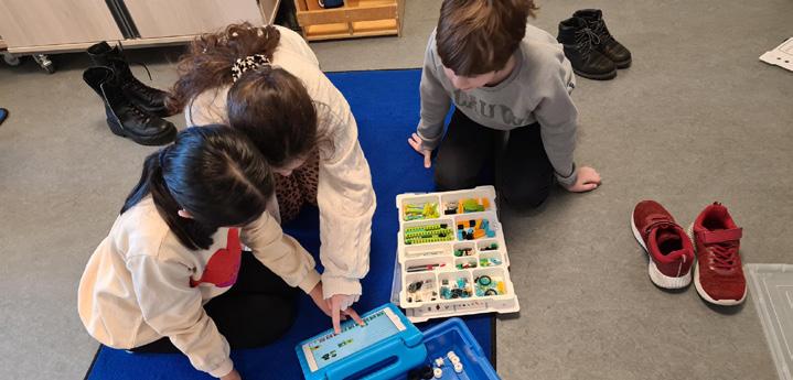 Leerlingen van de christelijke basisschool De Spiegel in Den Haag werken samen met educatief speelgoed op een blauwe mat. Leerlingen van de christelijke basisschool De Spiegel in Den Haag werken samen met educatief speelgoed op een blauwe mat.