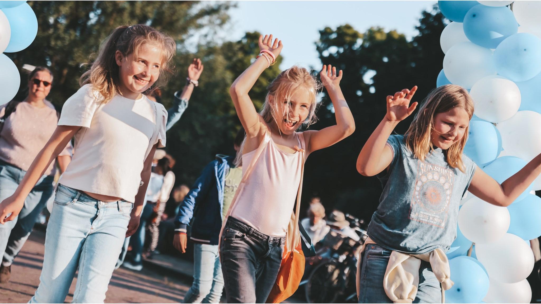 Leerlingen van de Dr. De Visserschool in Breda genieten van een vrolijke activiteit op het schoolplein.