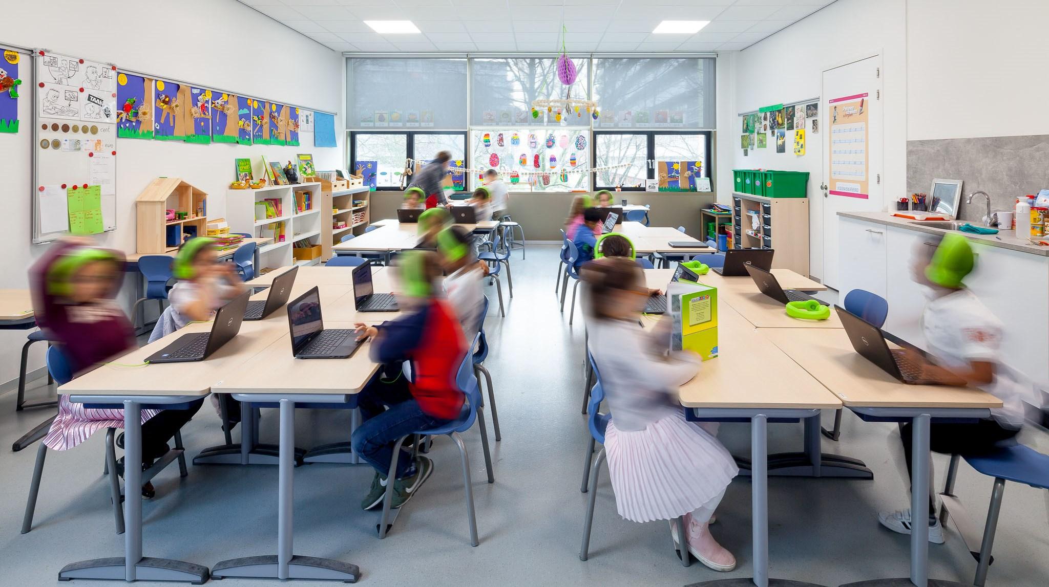 Leerlingen van de Immanuelschool in Amsterdam zijn actief bezig met laptops in een moderne klaslokaalomgeving. Leerlingen van de Immanuelschool in Amsterdam zijn actief bezig met laptops in een moderne klaslokaalomgeving.