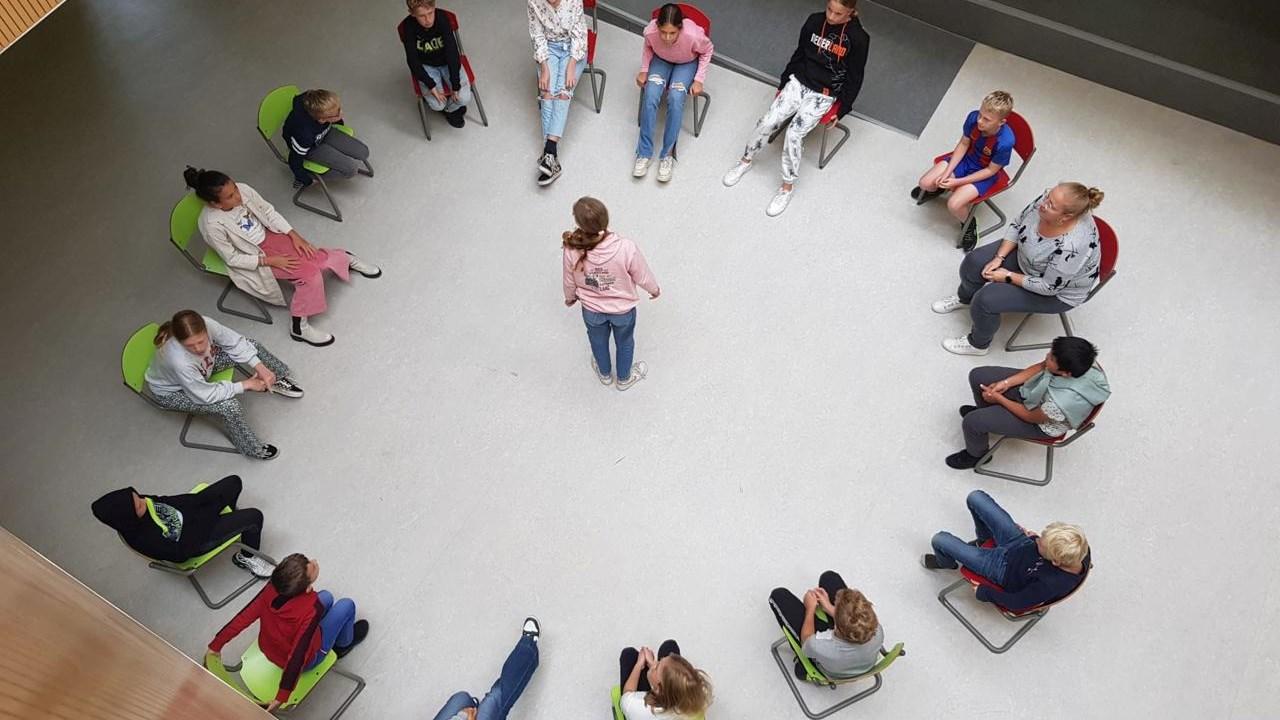 Leerlingen van de Immanuelschool in Oudewater nemen deel aan een groepsactiviteit in een cirkelopstelling. Leerlingen van de Immanuelschool in Oudewater nemen deel aan een groepsactiviteit in een cirkelopstelling.