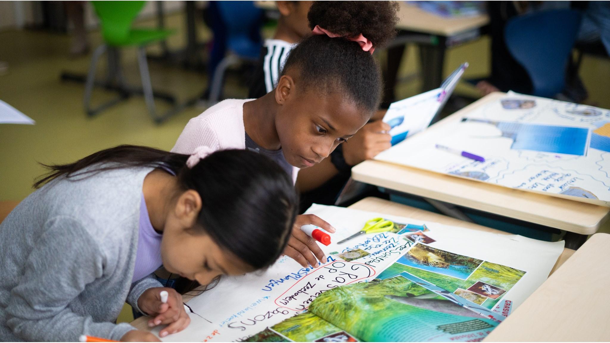 Leerlingen van De Kleine Wereld in Almere zijn actief aan het tekenen en schrijven aan een project op school. Leerlingen van De Kleine Wereld in Almere zijn actief aan het tekenen en schrijven aan een project op school.