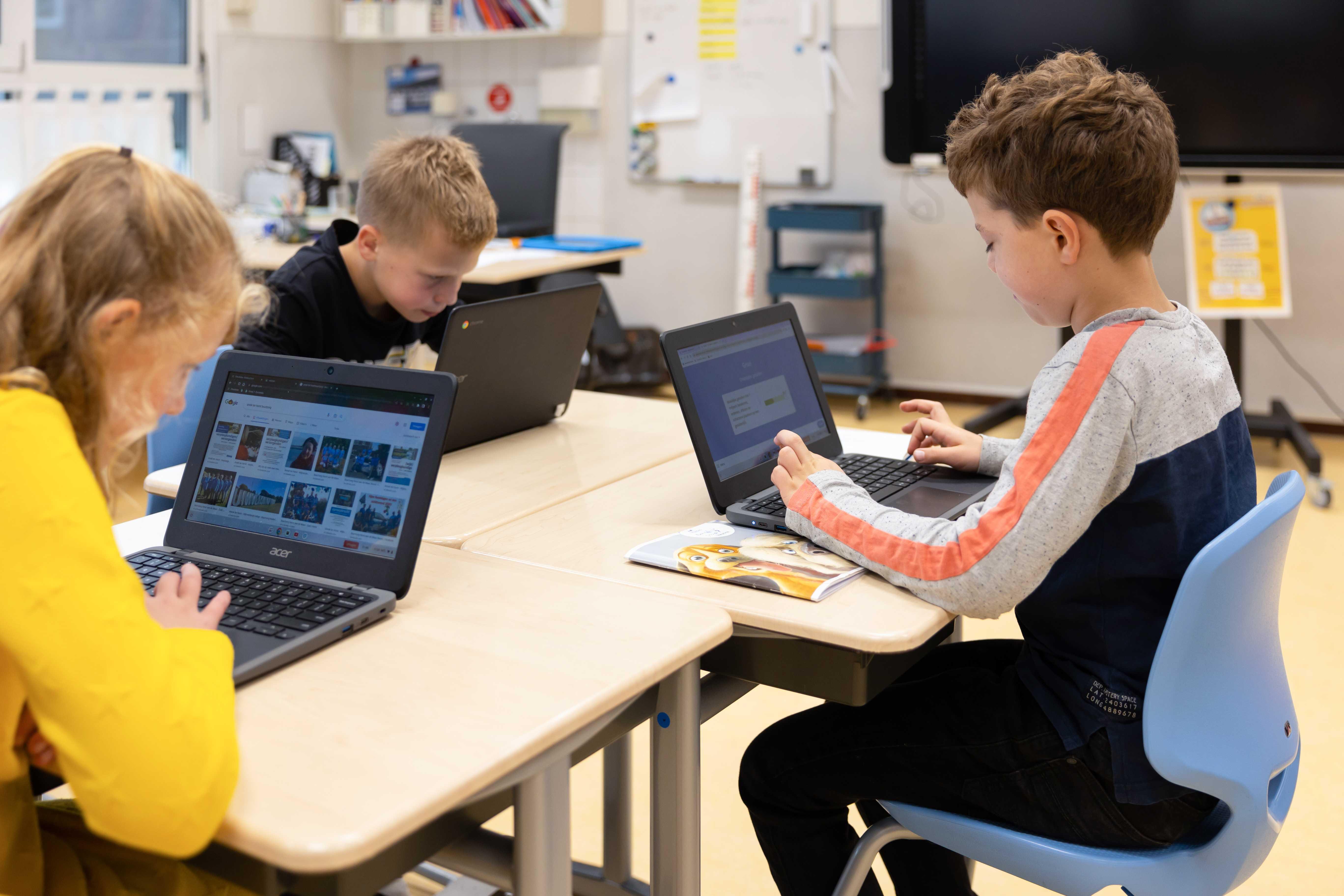 Leerlingen van de Mariaschool in Beuningen (Overijssel) werken geconcentreerd aan hun laptops tijdens een les. Leerlingen van de Mariaschool in Beuningen (Overijssel) werken geconcentreerd aan hun laptops tijdens een les.