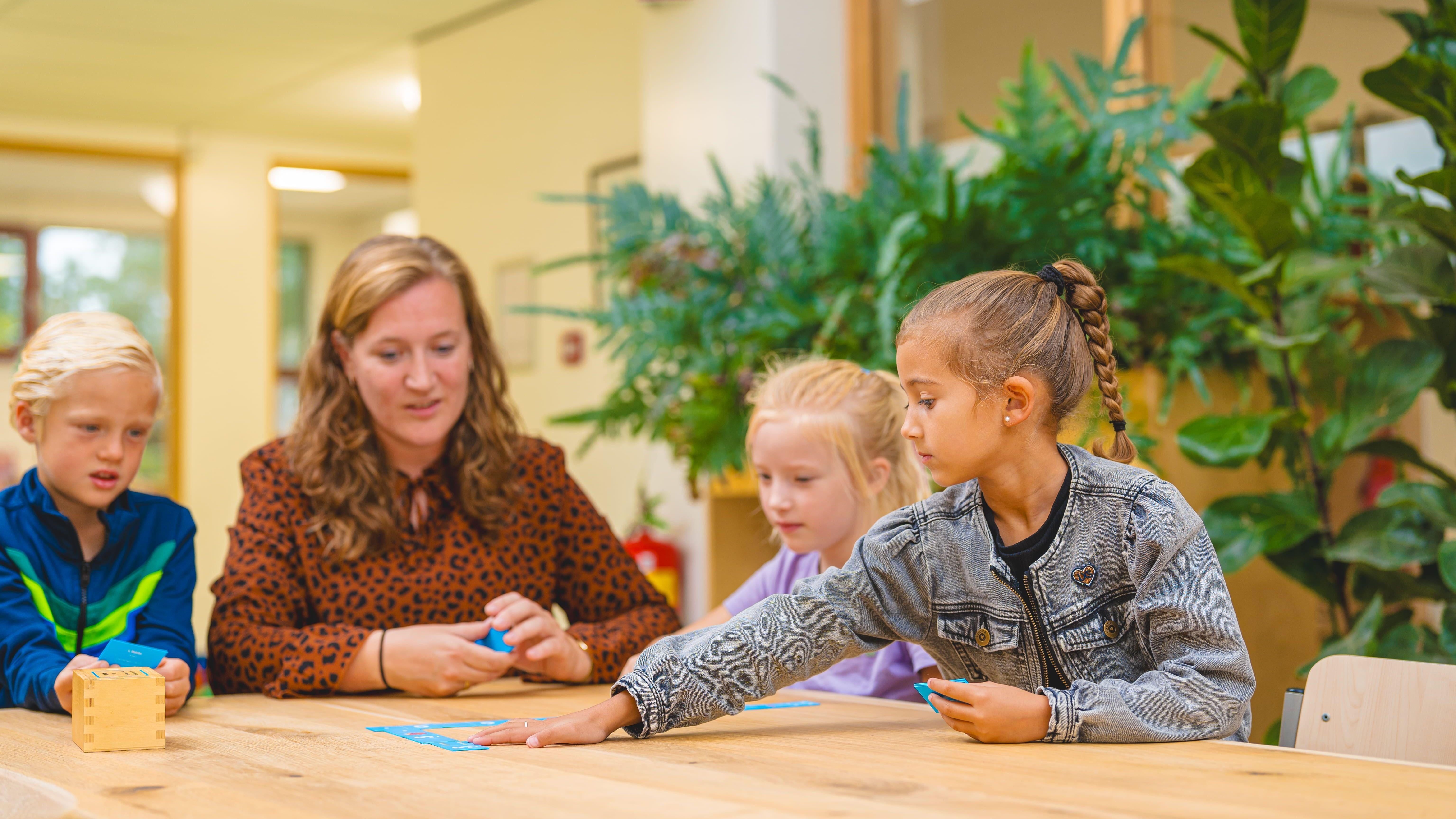 Leerlingen van de Nederlands Hervormde Basisschool Bethel in Waddinxveen zijn samen bezig met een activiteit aan een houten tafel. Leerlingen van de Nederlands Hervormde Basisschool Bethel in Waddinxveen zijn samen bezig met een activiteit aan een houten tafel.