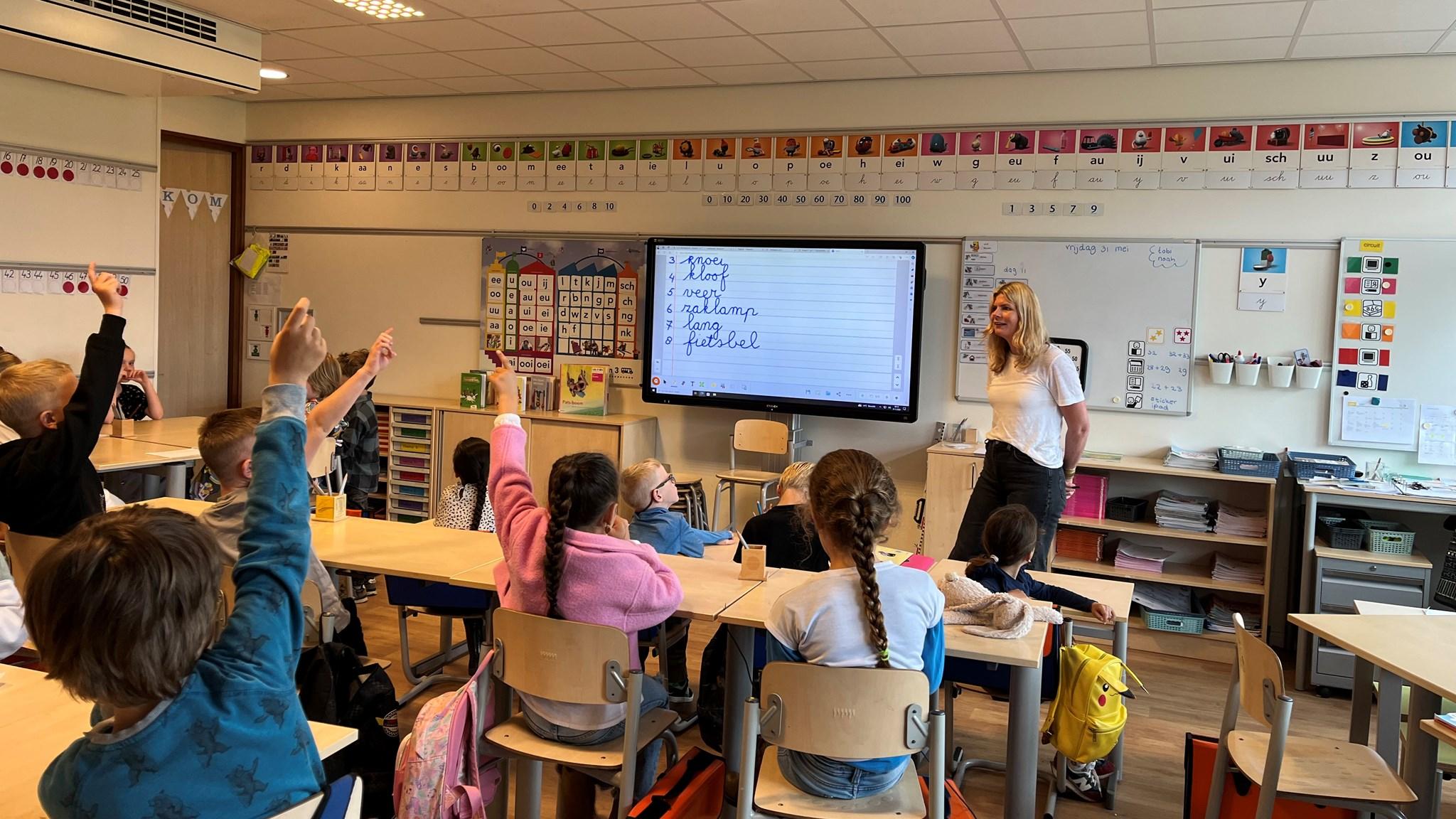 Leerlingen van de O.G. Heldringschool in Den Haag steken hun handen op tijdens een les. Leerlingen van de O.G. Heldringschool in Den Haag steken hun handen op tijdens een les.
