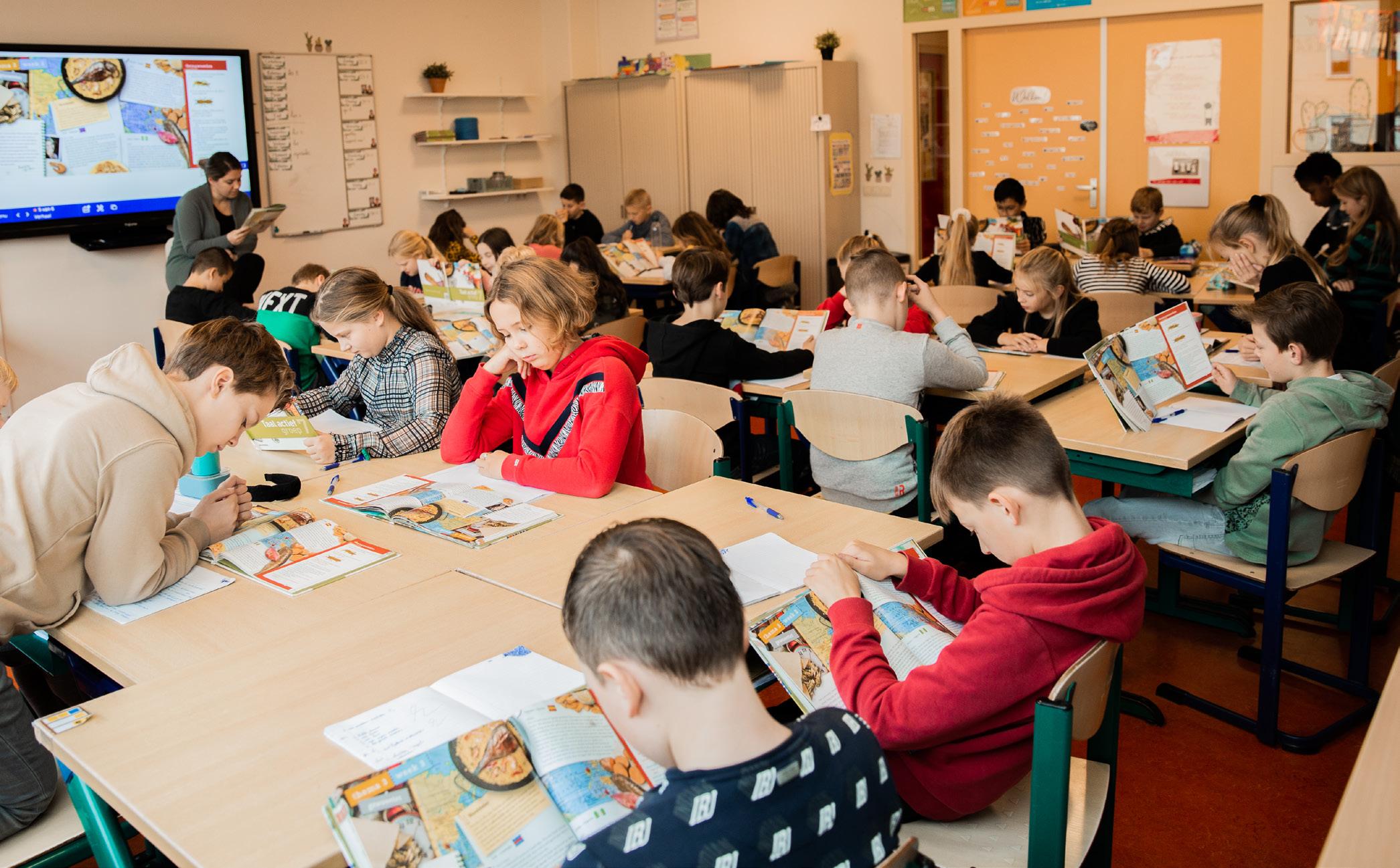 Leerlingen van de Paasbergschool in Ede zijn geconcentreerd bezig met hun schoolwerk in het klaslokaal.