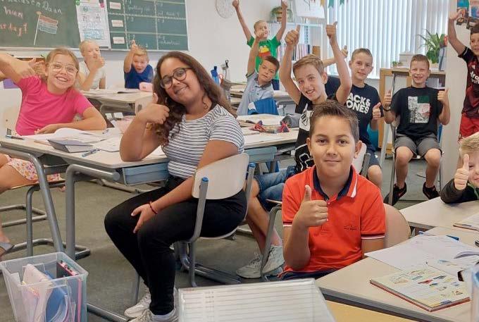 Leerlingen van de Prins Mauritsschool in Delft lachen en tonen een duim omhoog in de klas. Leerlingen van de Prins Mauritsschool in Delft lachen en tonen een duim omhoog in de klas.