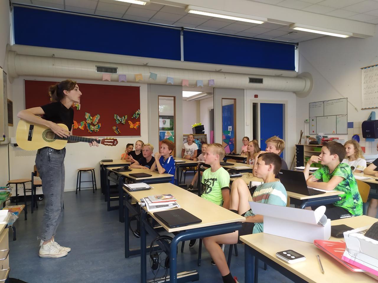 Leerlingen van de Prins Willem Alexanderschool in Ophemert luisteren aandachtig naar een muziekles met een gitaar. Leerlingen van de Prins Willem Alexanderschool in Ophemert luisteren aandachtig naar een muziekles met een gitaar.