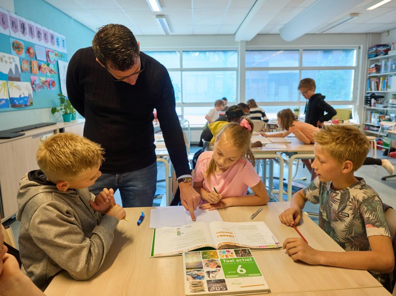 Leerlingen van de Rehobothschool voor Reformatorisch Onderwijs in Zeist werken samen in de klas met een leraar. Leerlingen van de Rehobothschool voor Reformatorisch Onderwijs in Zeist werken samen in de klas met een leraar.