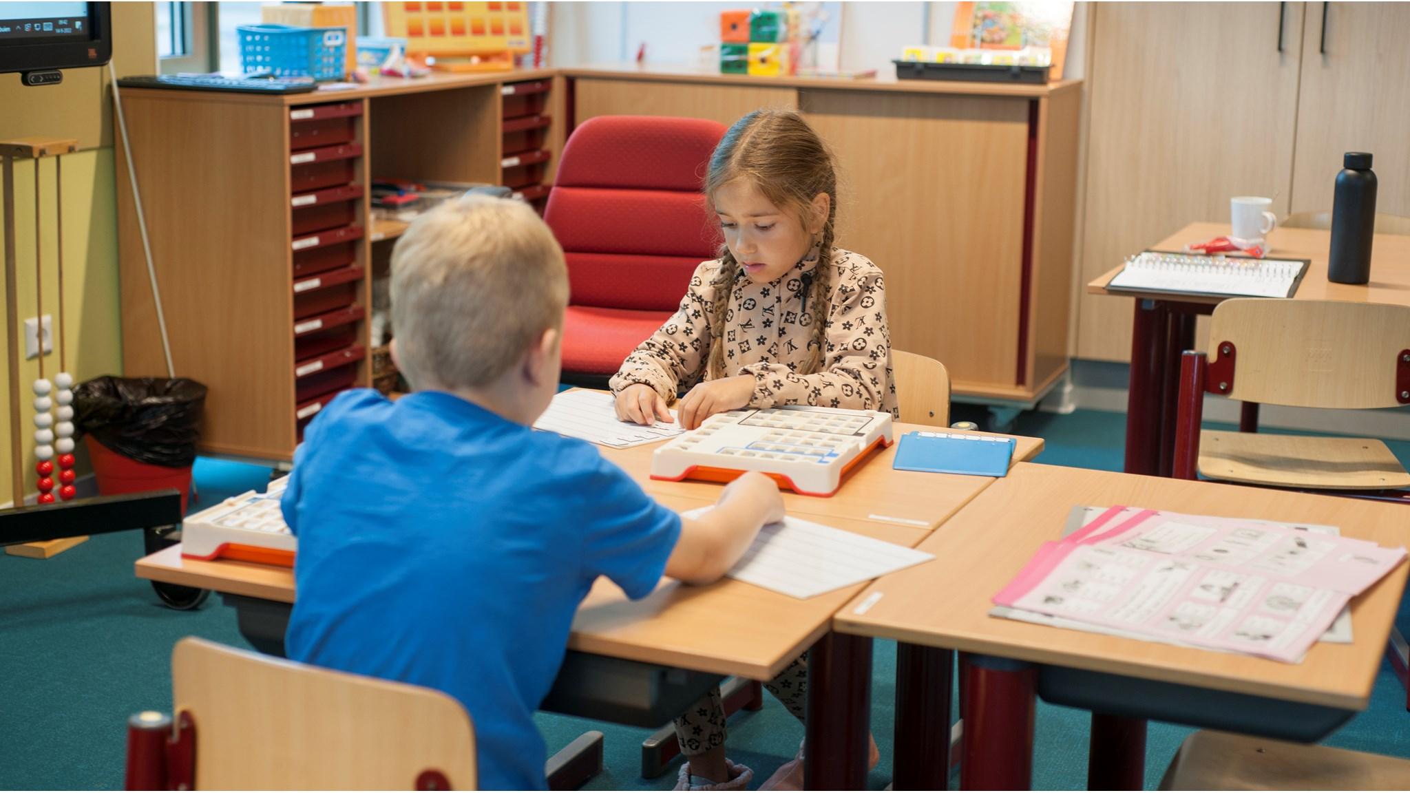 Leerlingen van de School voor Speciaal Basisonderwijs De Meie in Zierikzee zijn aan het werken aan hun oefeningen aan een tafel in de klas. Leerlingen van de School voor Speciaal Basisonderwijs De Meie in Zierikzee zijn aan het werken aan hun oefeningen aan een tafel in de klas.