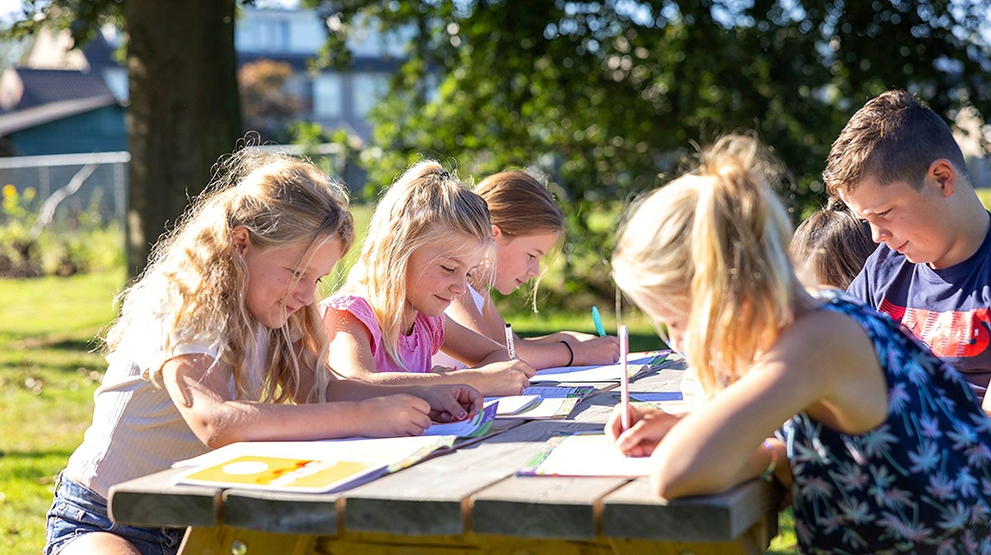 Leerlingen van De Sprenge Emst werken buiten aan hun schoolopdrachten op het schoolplein. Leerlingen van De Sprenge Emst werken buiten aan hun schoolopdrachten op het schoolplein.