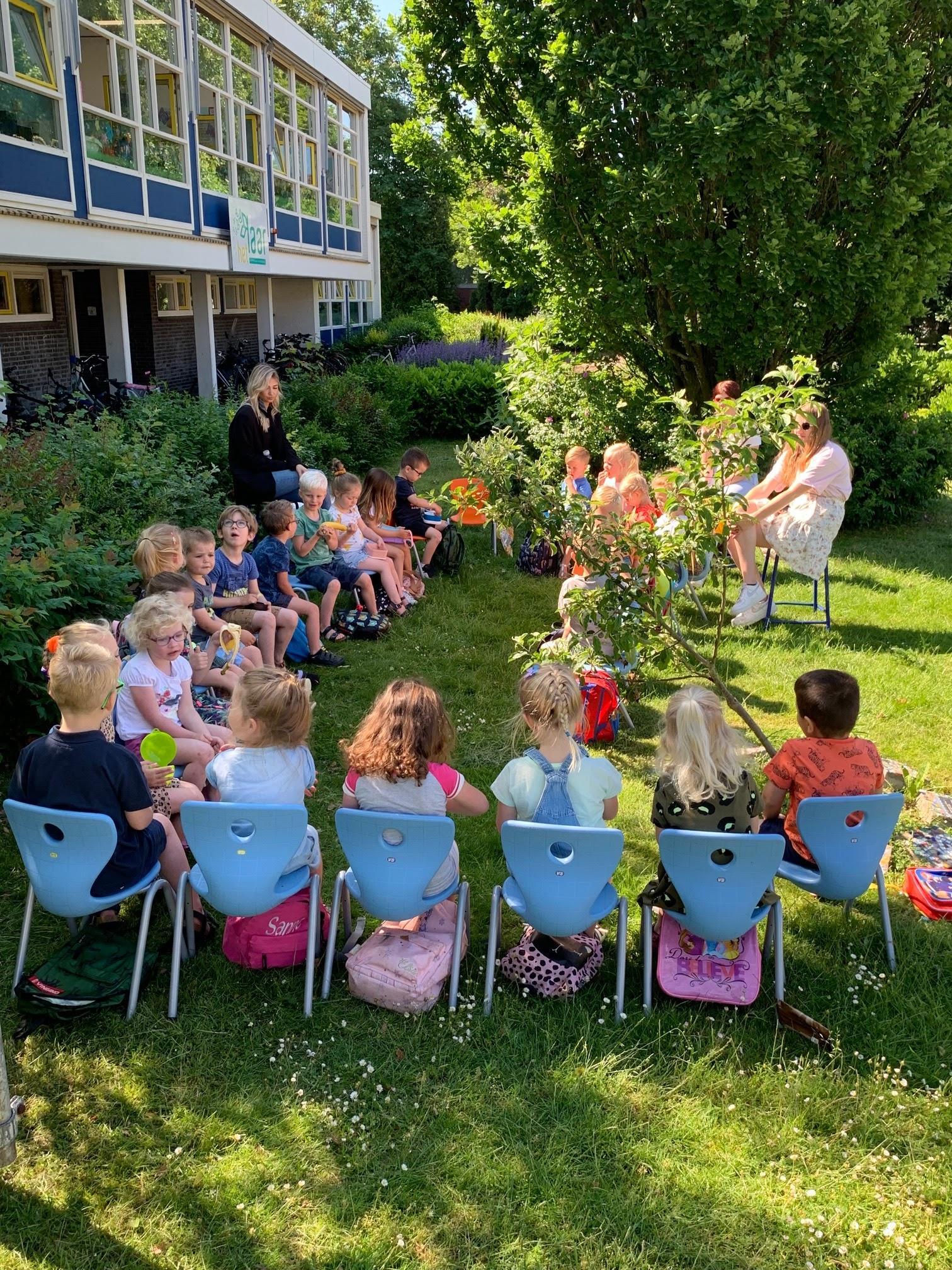 Leerlingen van De Wending in Roosendaal zitten in een cirkel op het schoolplein tijdens een buitenles. Leerlingen van De Wending in Roosendaal zitten in een cirkel op het schoolplein tijdens een buitenles.