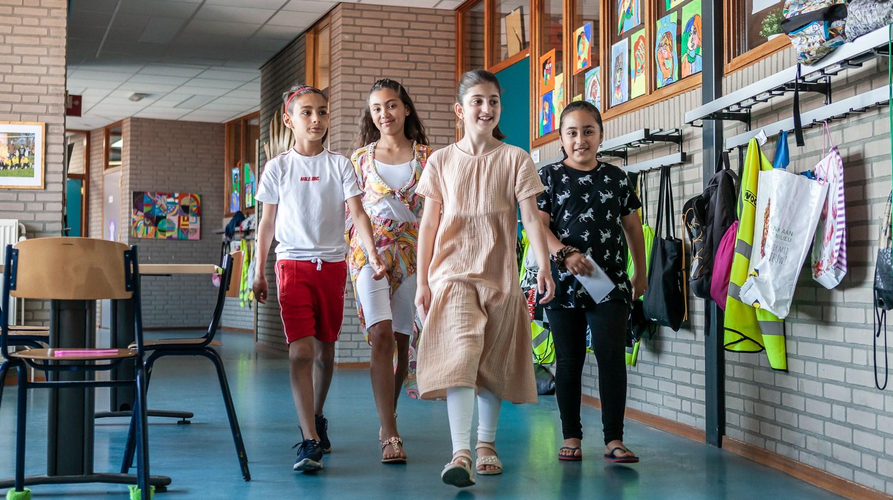 Leerlingen van De Zonnewijzer in Roermond lopen door de schoolgang. Leerlingen van De Zonnewijzer in Roermond lopen door de schoolgang.