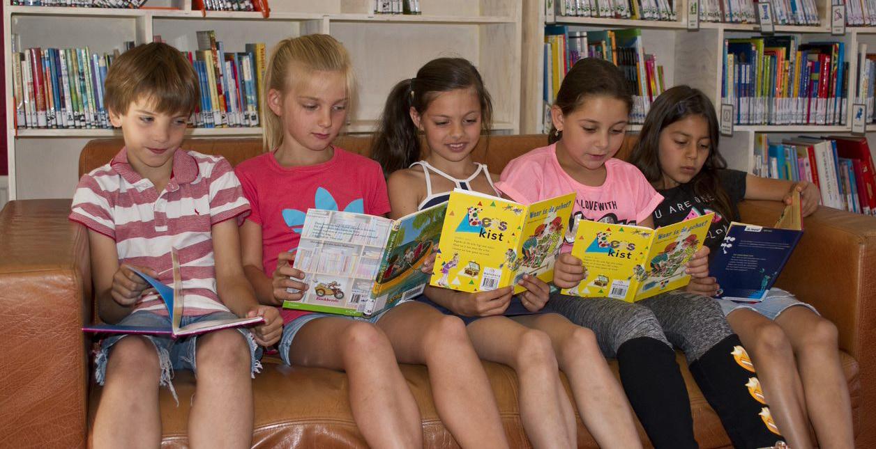 Leerlingen van DKC Jan Ligthart in Zutphen lezen samen boeken op een bank. Leerlingen van DKC Jan Ligthart in Zutphen lezen samen boeken op een bank.