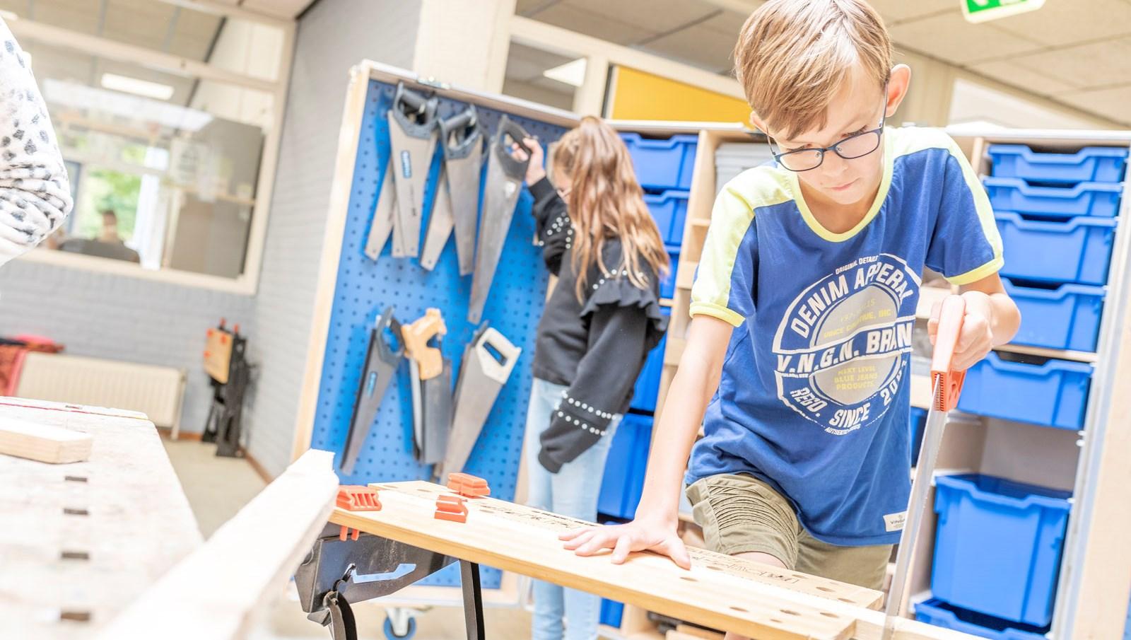Leerlingen van Het Zuiderlicht in Dronten zijn actief bezig met een houtbewerkingstaak in het klaslokaal. Leerlingen van Het Zuiderlicht in Dronten zijn actief bezig met een houtbewerkingstaak in het klaslokaal.