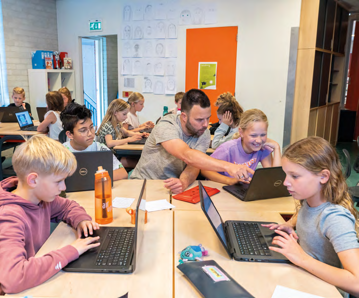Leerlingen van IKC de Driemaster in Hoek van Holland werken samen aan laptops onder begeleiding van een docent. Leerlingen van IKC de Driemaster in Hoek van Holland werken samen aan laptops onder begeleiding van een docent.