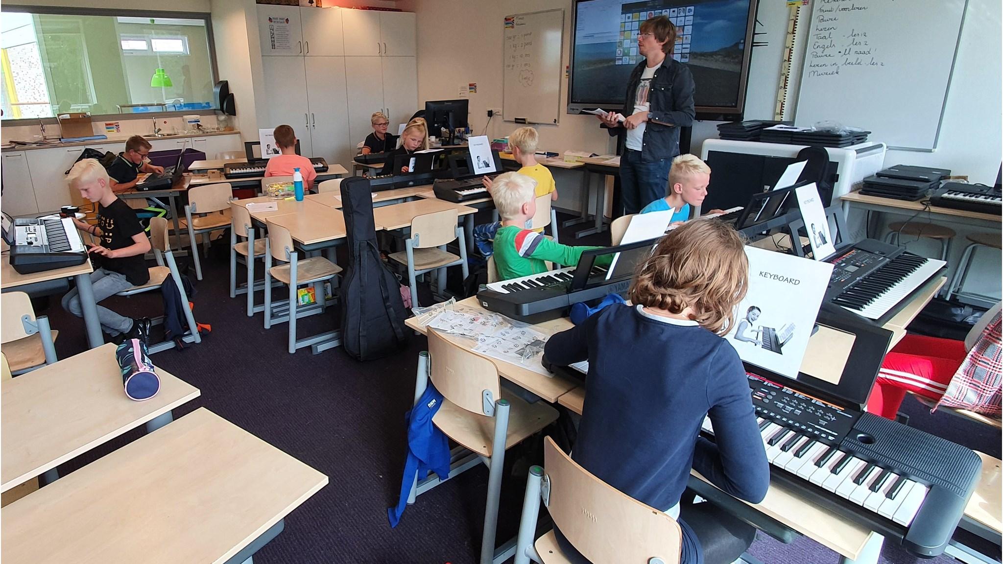 Leerlingen van IKC De Fugelsang in Berlikum volgen muziekles achter toetsenborden. Leerlingen van IKC De Fugelsang in Berlikum volgen muziekles achter toetsenborden.