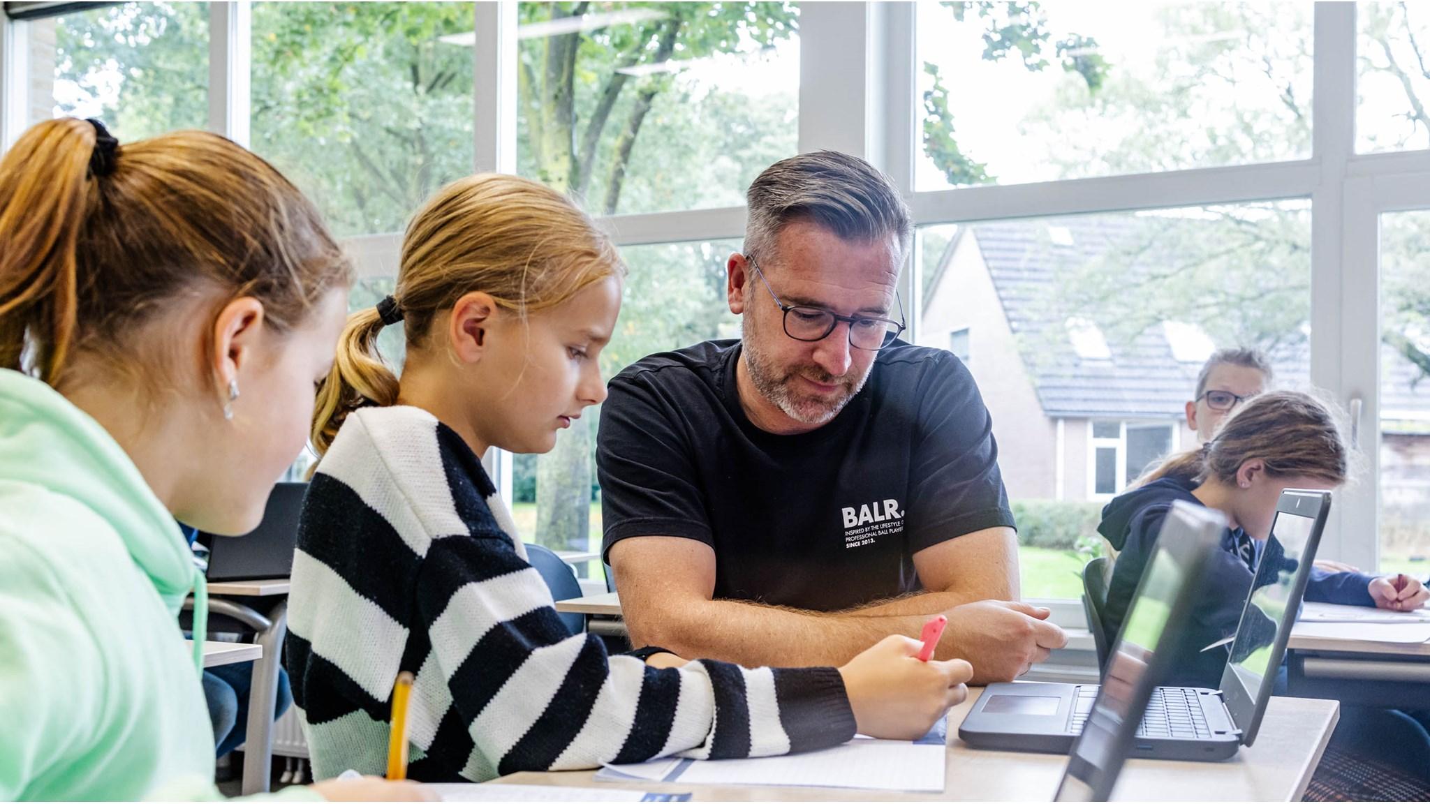 Leerlingen van IKC Hart van Slangenbeek in Hengelo werken samen met een leraar aan hun schoolwerk. Leerlingen van IKC Hart van Slangenbeek in Hengelo werken samen met een leraar aan hun schoolwerk.
