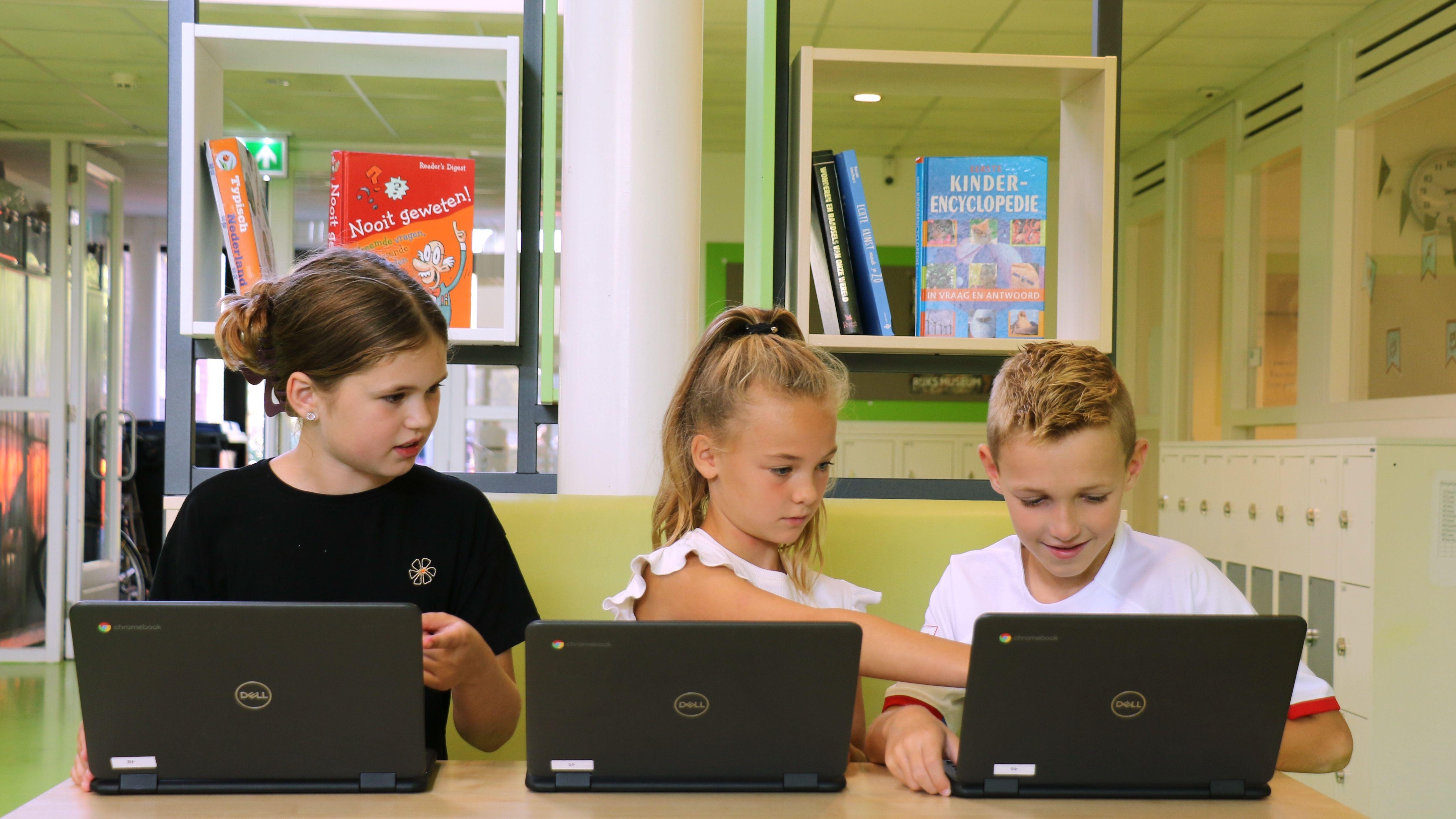 Leerlingen van IKC Prins Claus in Zoetermeer werken samen aan hun laptops in een moderne leeromgeving. Leerlingen van IKC Prins Claus in Zoetermeer werken samen aan hun laptops in een moderne leeromgeving.