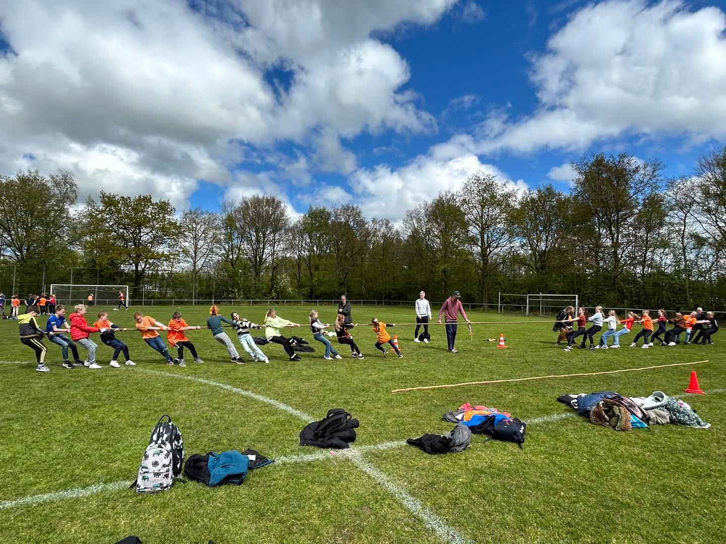 Leerlingen van It Kruirêd in Mûnein spelen touwtrekken op het schoolplein.