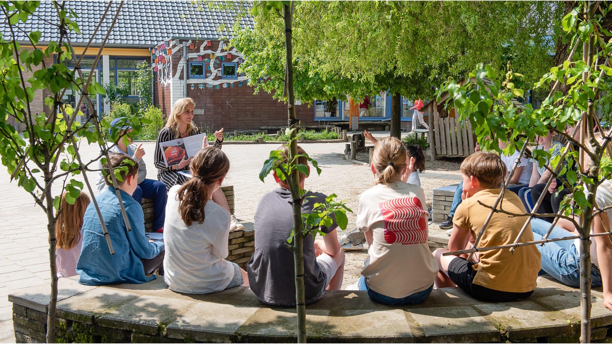 Leerlingen van Jenaplan IKC Donatushof in Bemmel luisteren aandachtig naar een leerkracht in het schoolplein. Leerlingen van Jenaplan IKC Donatushof in Bemmel luisteren aandachtig naar een leerkracht in het schoolplein.