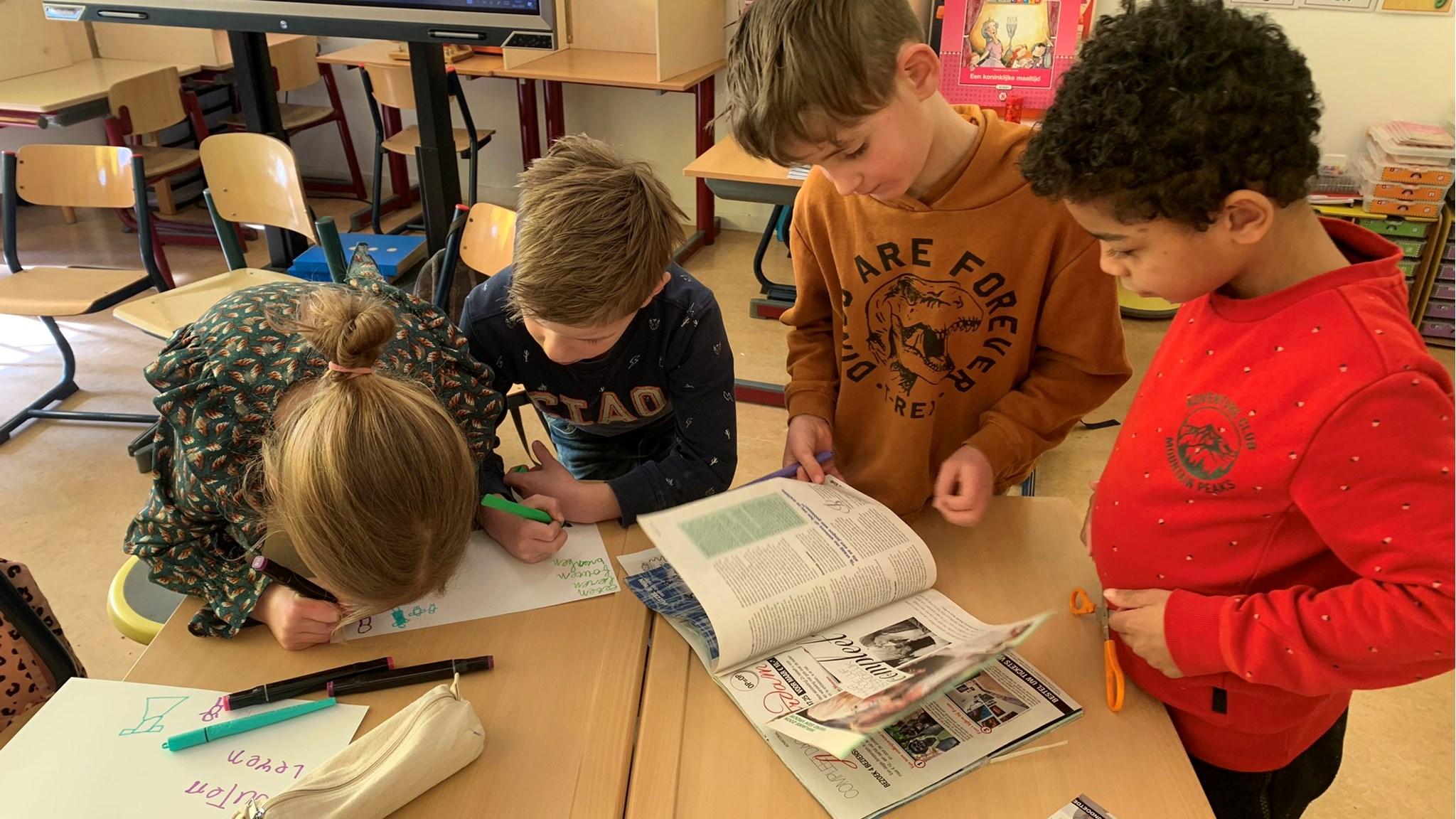 Leerlingen van Kindcentrum De Morgenster in Kerkwerve werken samen aan creatieve opdrachten aan hun bureau.