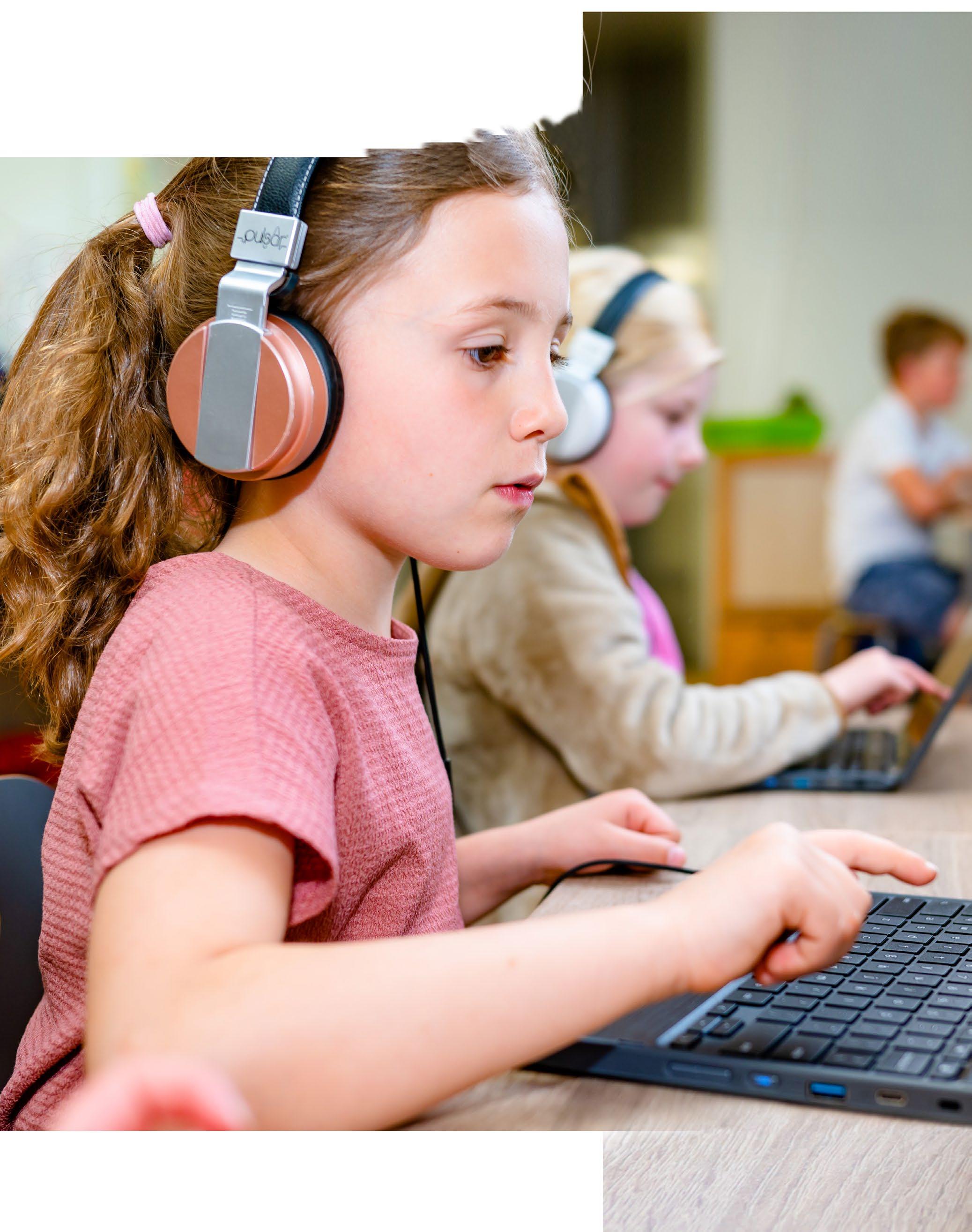 Leerlingen van Kindcentrum De Morgenster in Zwolle werken geconcentreerd met laptops en koptelefoons.