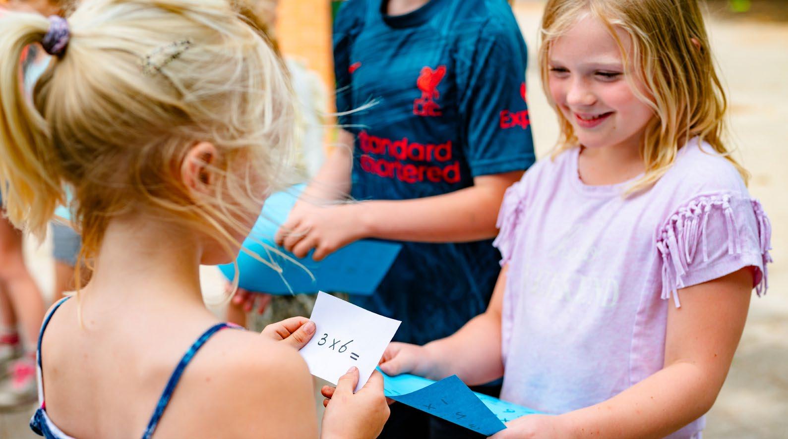 Leerlingen van Kindcentrum De Morgenster in Zwolle zijn actief bezig met een rekenspel op het schoolplein.
