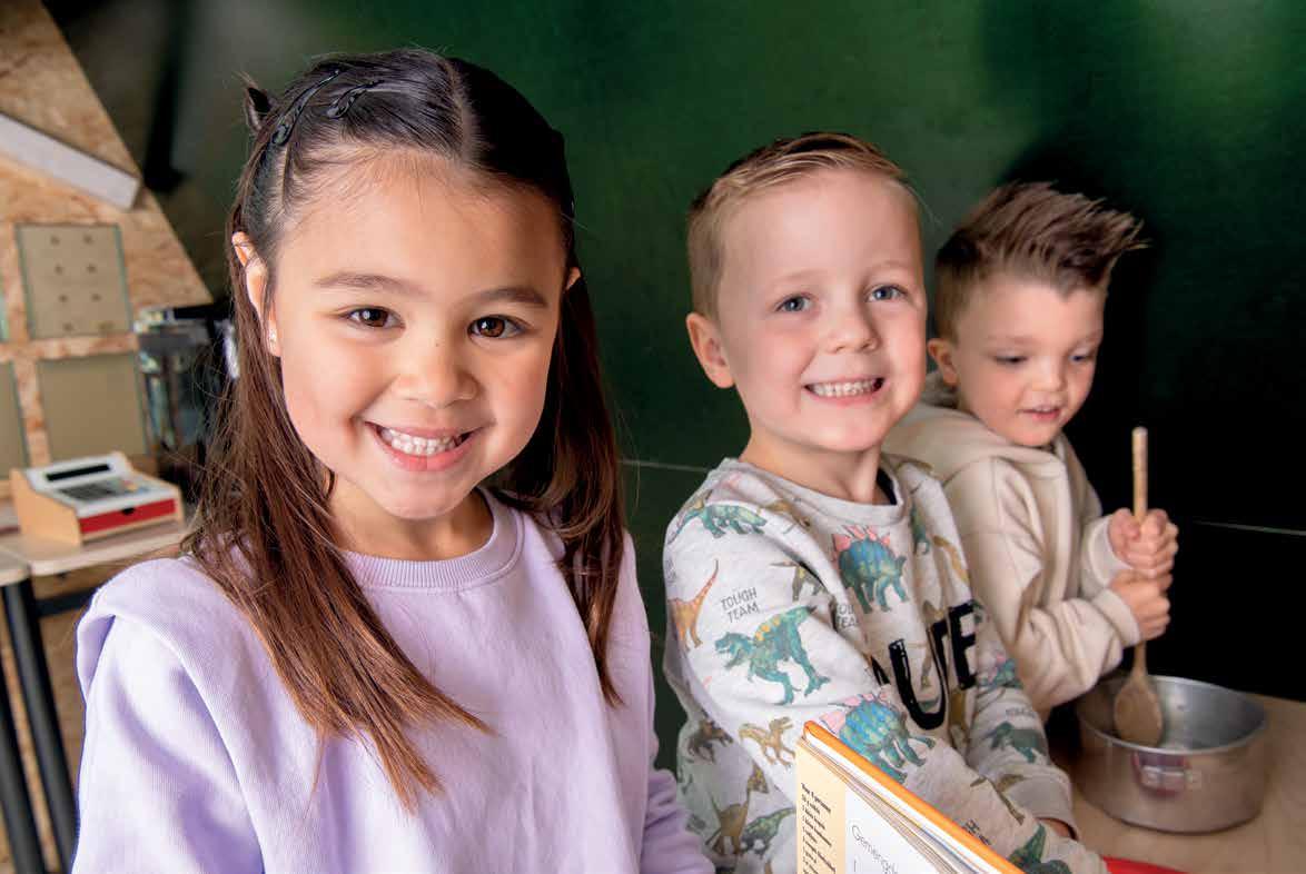 Leerlingen van Kindcentrum De Spreng in Hoevelaken glimlachen terwijl ze samen bezig zijn met een activiteit. Leerlingen van Kindcentrum De Spreng in Hoevelaken glimlachen terwijl ze samen bezig zijn met een activiteit.