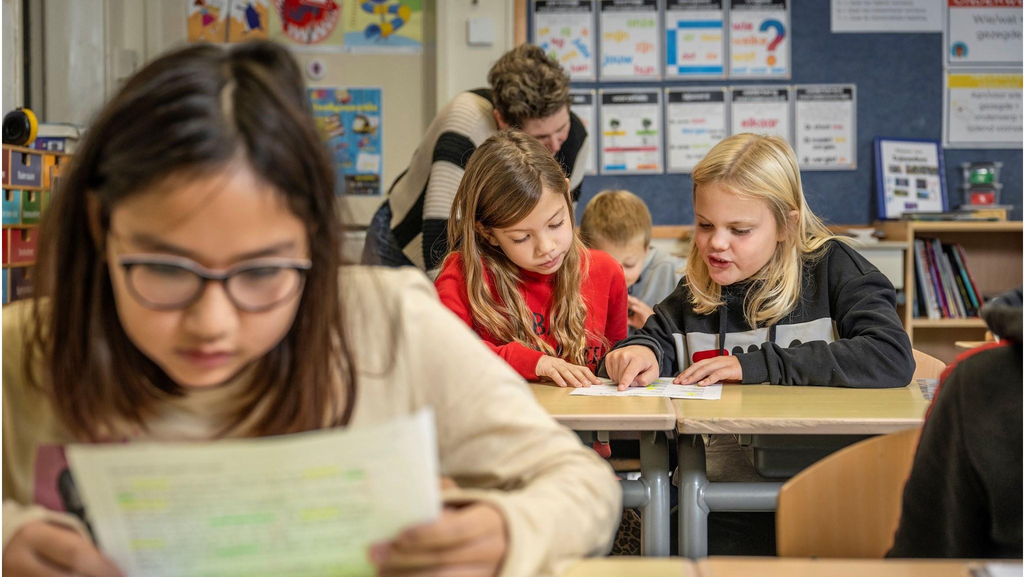 Leerlingen van Kindcentrum Eikerwijs in Kessel werken samen aan hun schoolwerk in een klaslokaal.