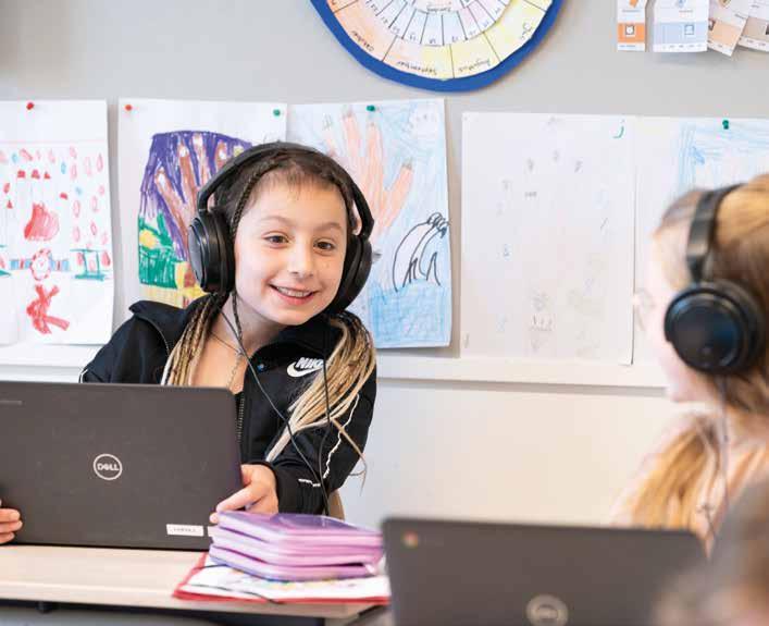 Leerlingen van KPO Basisschool Joseph in Roosendaal werken met laptops en headphones in een klaslokaal. Leerlingen van KPO Basisschool Joseph in Roosendaal werken met laptops en headphones in een klaslokaal.