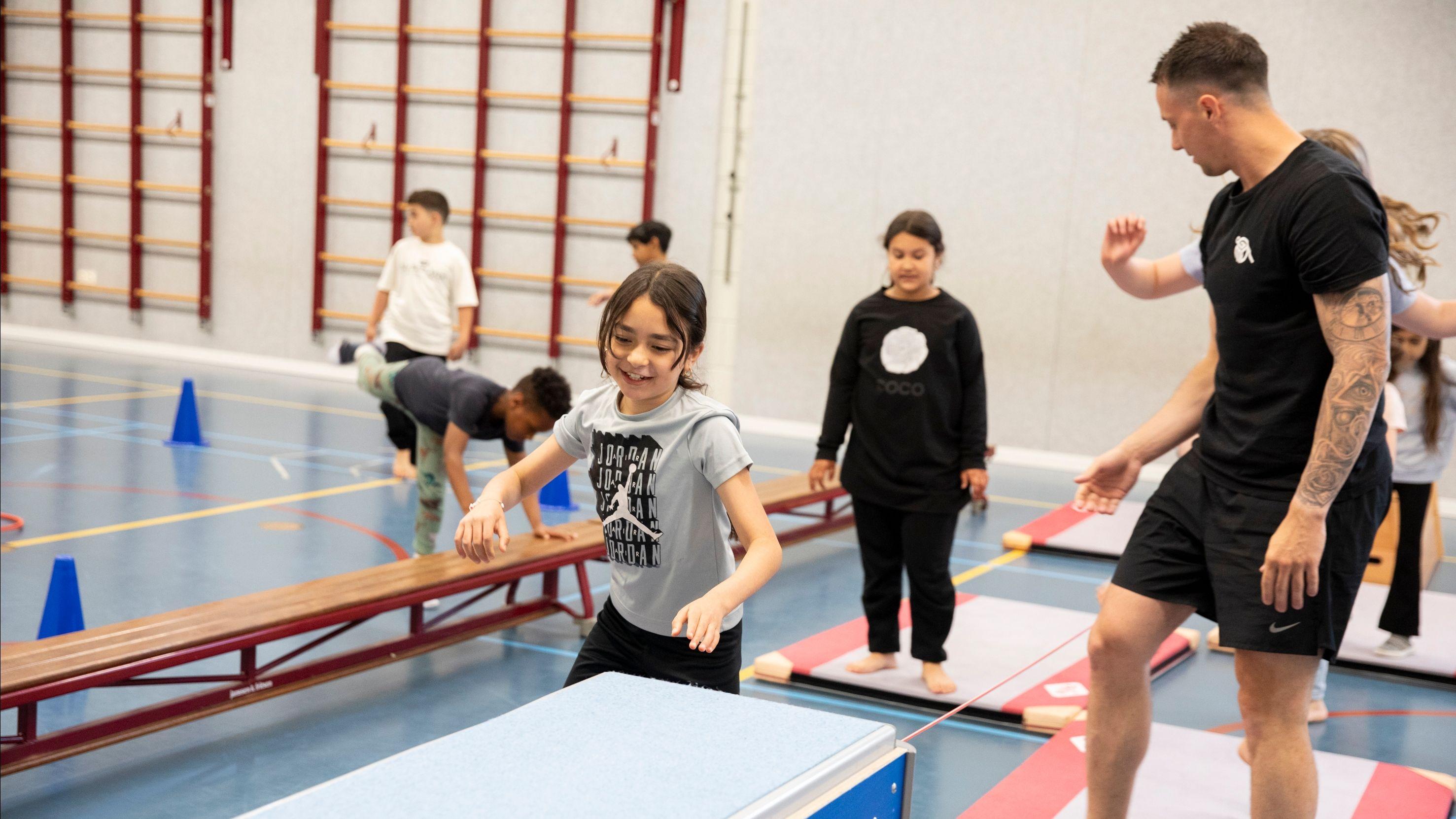 Leerlingen van Obs Charlois in Rotterdam oefenen gymnastic vaardigheden in de gymzaal. Leerlingen van Obs Charlois in Rotterdam oefenen gymnastic vaardigheden in de gymzaal.