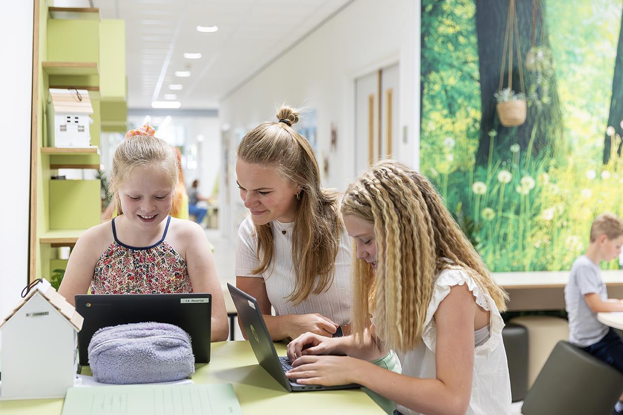 Leerlingen van obs De Dennenkamp in Ommen werken samen aan laptops in een moderne klasomgeving. Leerlingen van obs De Dennenkamp in Ommen werken samen aan laptops in een moderne klasomgeving.