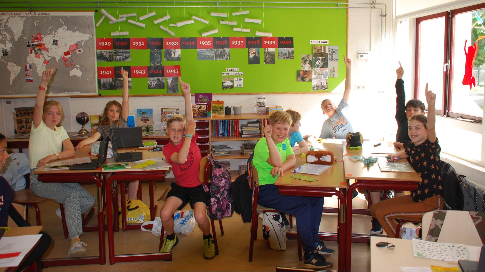 Leerlingen van obs De Dubbelburg in Valkenburg (Zuid-Holland) steken enthousiast hun hand omhoog in de klas. Leerlingen van obs De Dubbelburg in Valkenburg (Zuid-Holland) steken enthousiast hun hand omhoog in de klas.