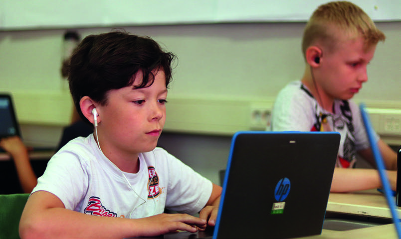 Leerlingen van obs Galvani in Den Haag werken geconcentreerd aan laptops in de klas. Leerlingen van obs Galvani in Den Haag werken geconcentreerd aan laptops in de klas.