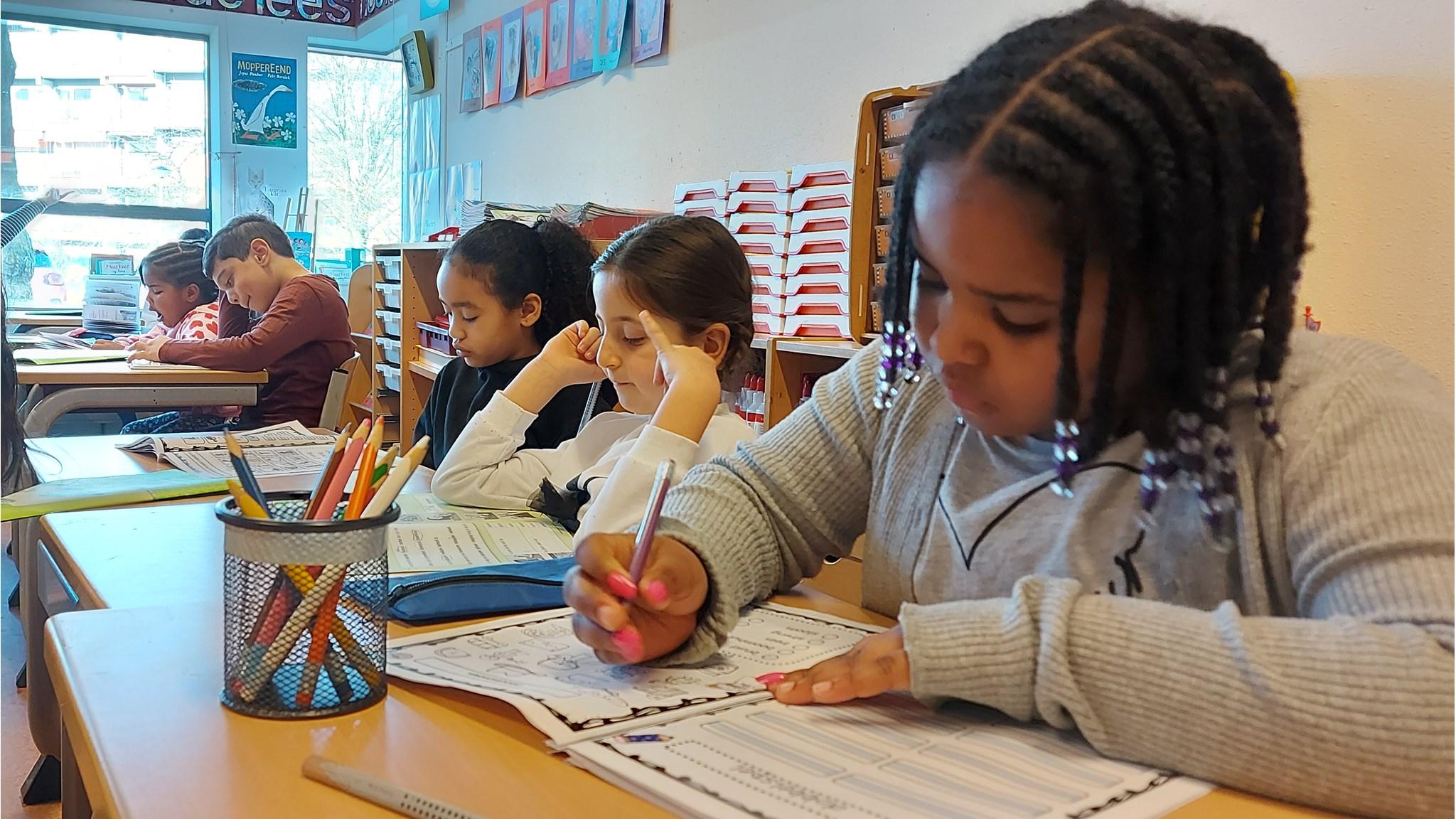 Leerlingen van Onze Wereld in Amsterdam zijn aan het werk in de klas. Leerlingen van Onze Wereld in Amsterdam zijn aan het werk in de klas.