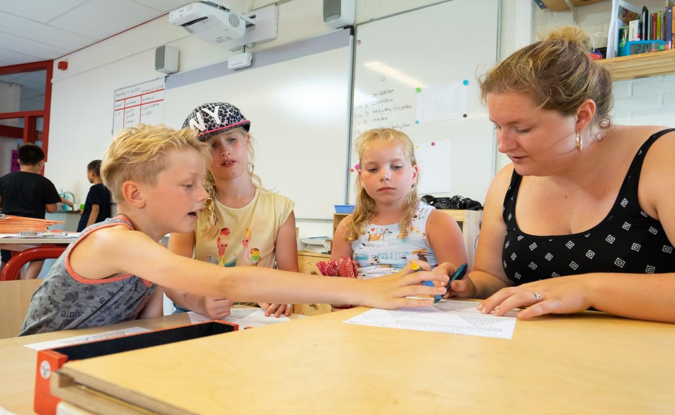 Leerlingen van Openbare Basisschool de Cocon in Alkmaar werken samen aan een opdracht met begeleiding van een docente. Leerlingen van Openbare Basisschool de Cocon in Alkmaar werken samen aan een opdracht met begeleiding van een docente.