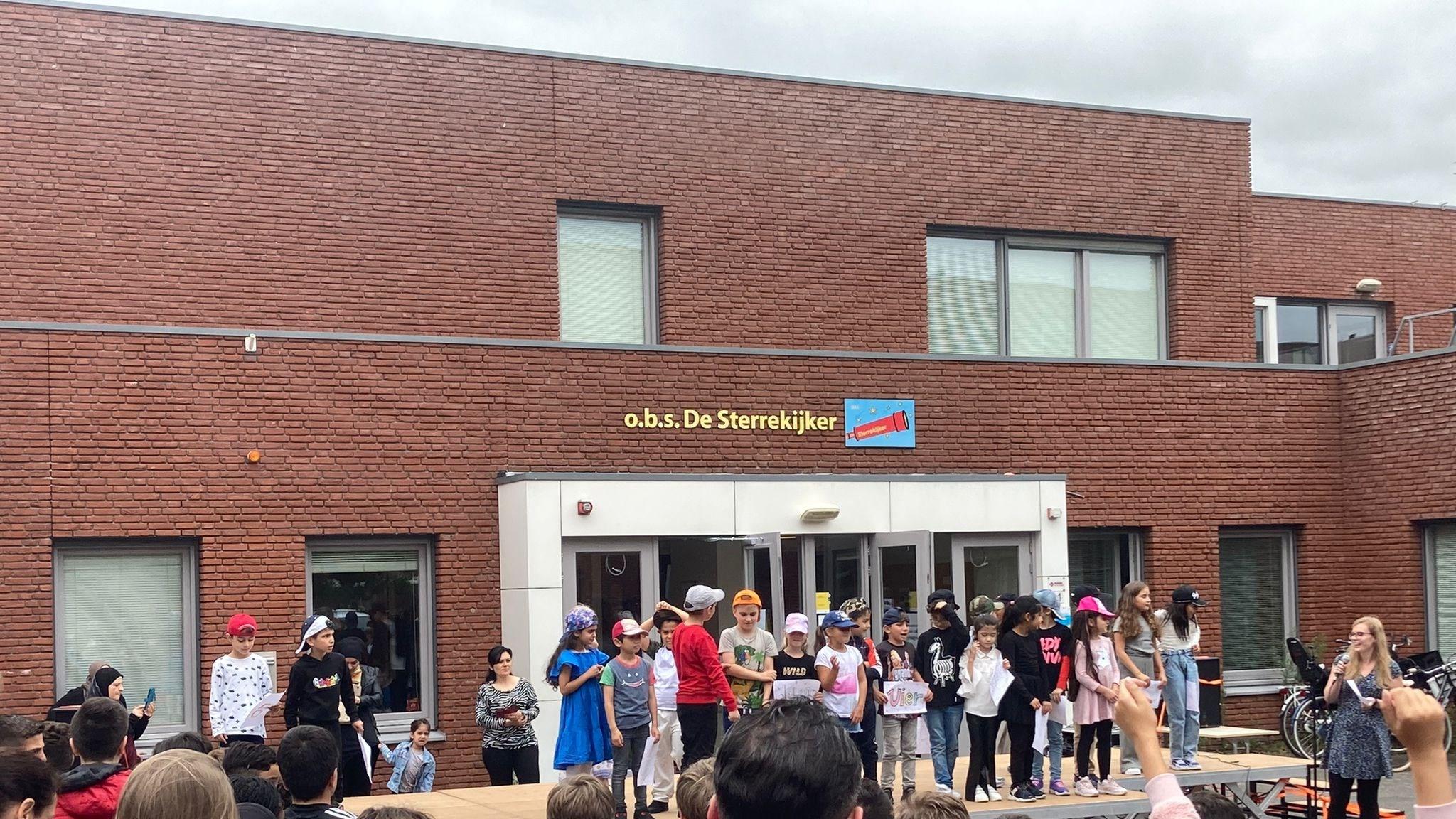 Leerlingen van Openbare Basisschool de Sterrenkijker in Beverwijk geven een optreden op het schoolplein. Leerlingen van Openbare Basisschool de Sterrenkijker in Beverwijk geven een optreden op het schoolplein.