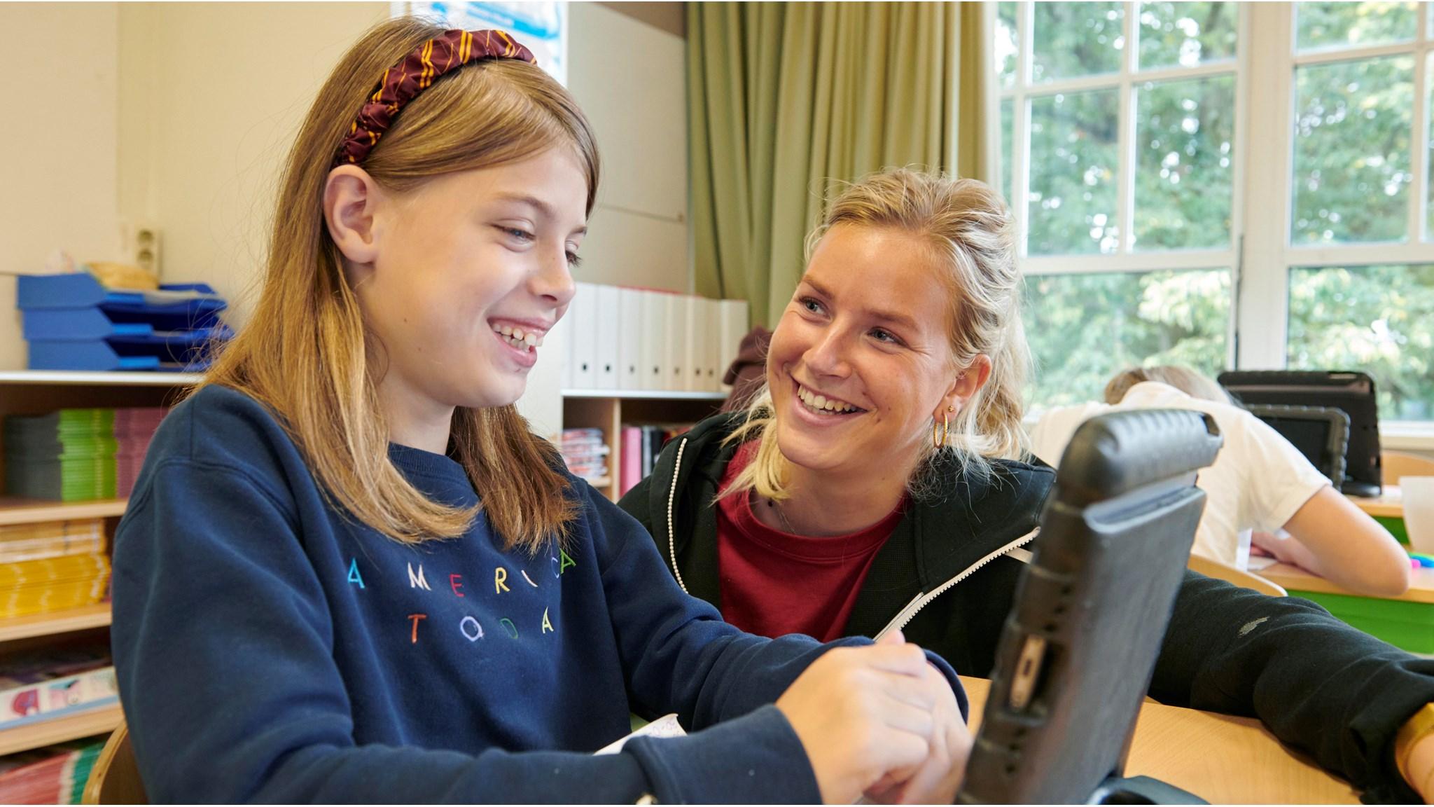 Leerlingen van Openbare Basisschool De Wilgenhoek in Haarlem werken samen aan een tablet.