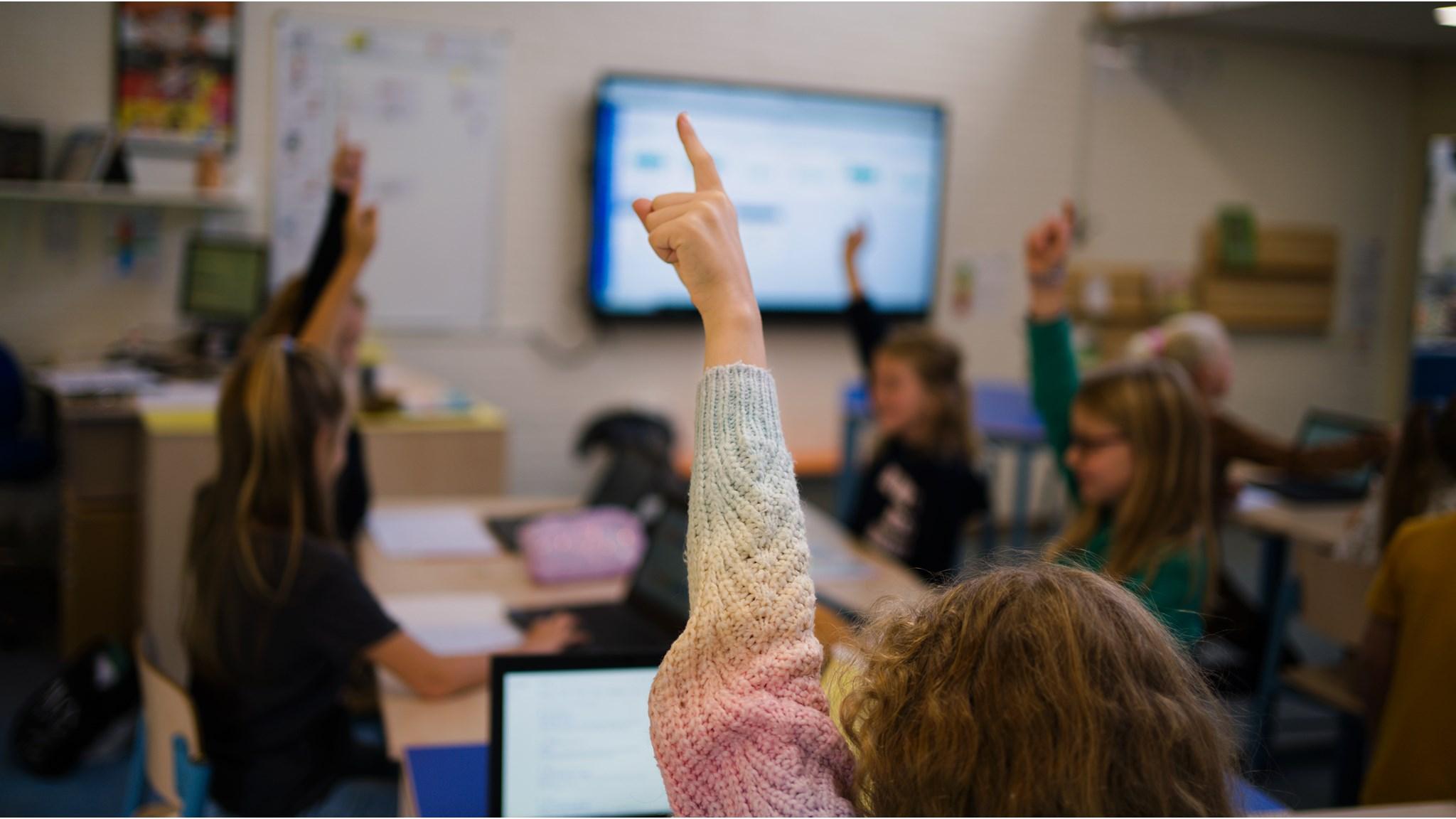 Leerlingen van Openbare Basisschool Flevosprong in Dronten steken hun handen op in de klas. Leerlingen van Openbare Basisschool Flevosprong in Dronten steken hun handen op in de klas.